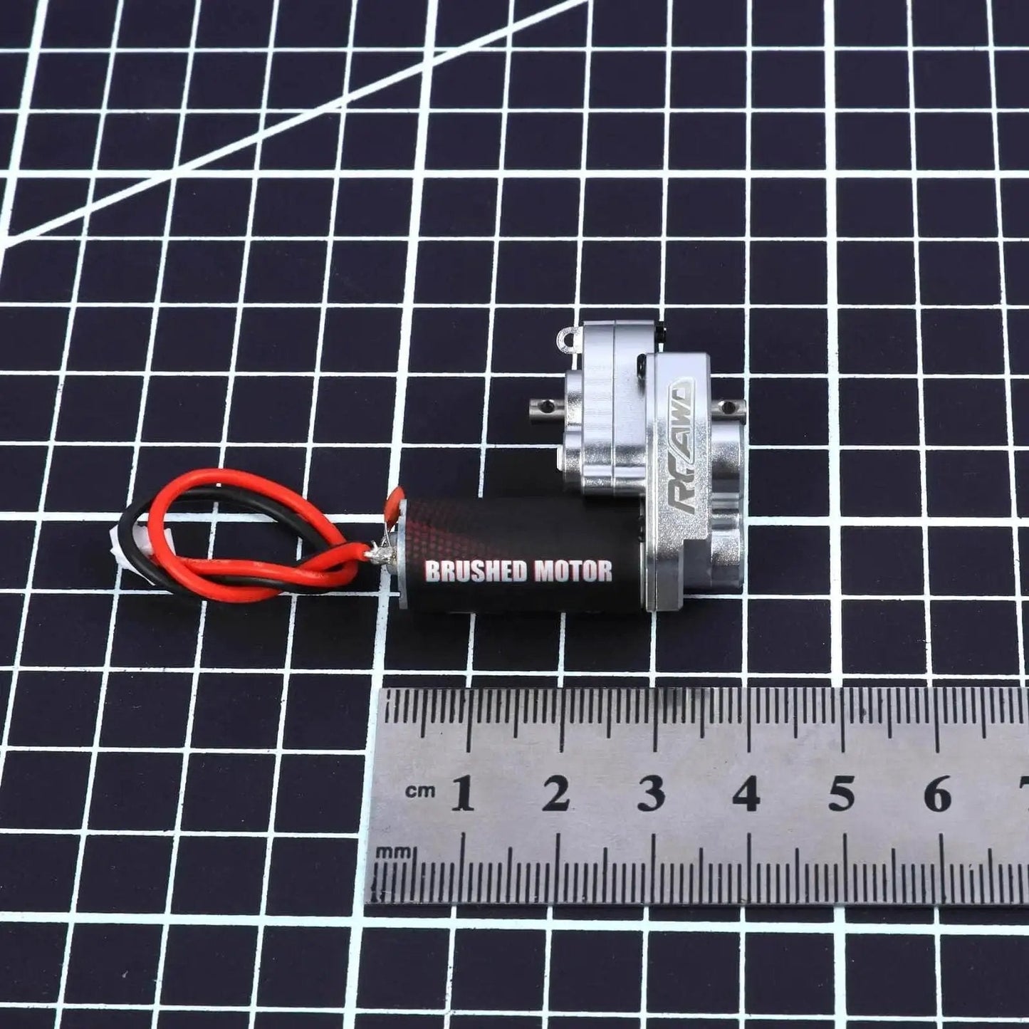 Upgraded 55T Carbon Brush 050 Motor with aluminum gear case for Axial SCX24 models, shown with ruler for scale.