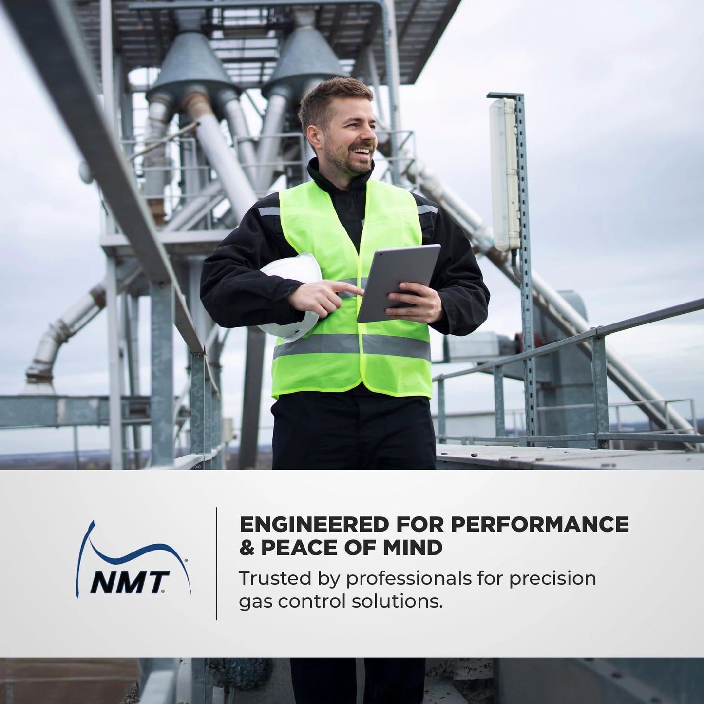 Man in safety vest holding tablet on industrial platform with text overlay 'Engineered for Performance & Peace of Mind' by NMT.