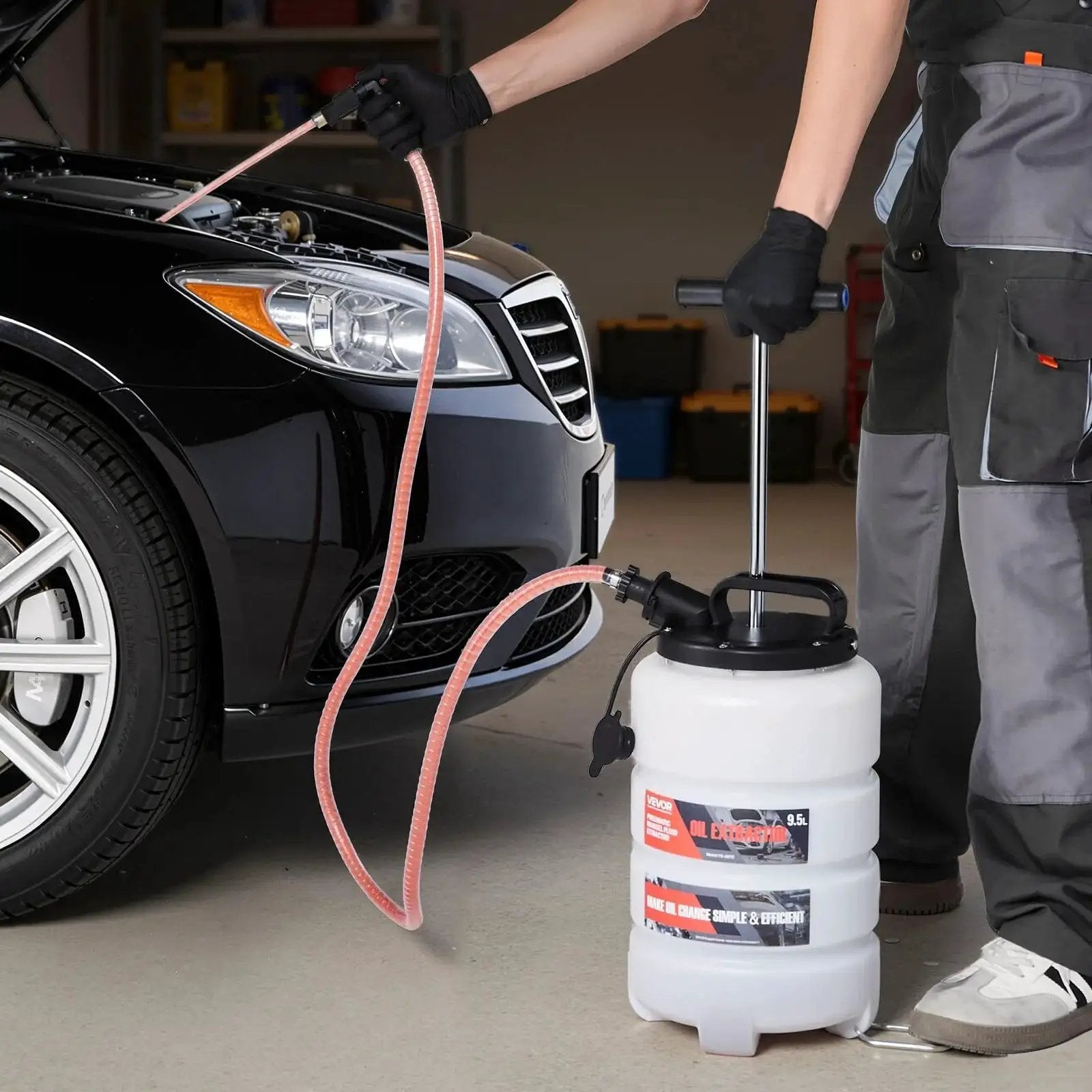 Mechanic using 9.5 L Manual Oil Change Fluid Extractor Pump With Long Hose And Extension Tubes next to a car engine
