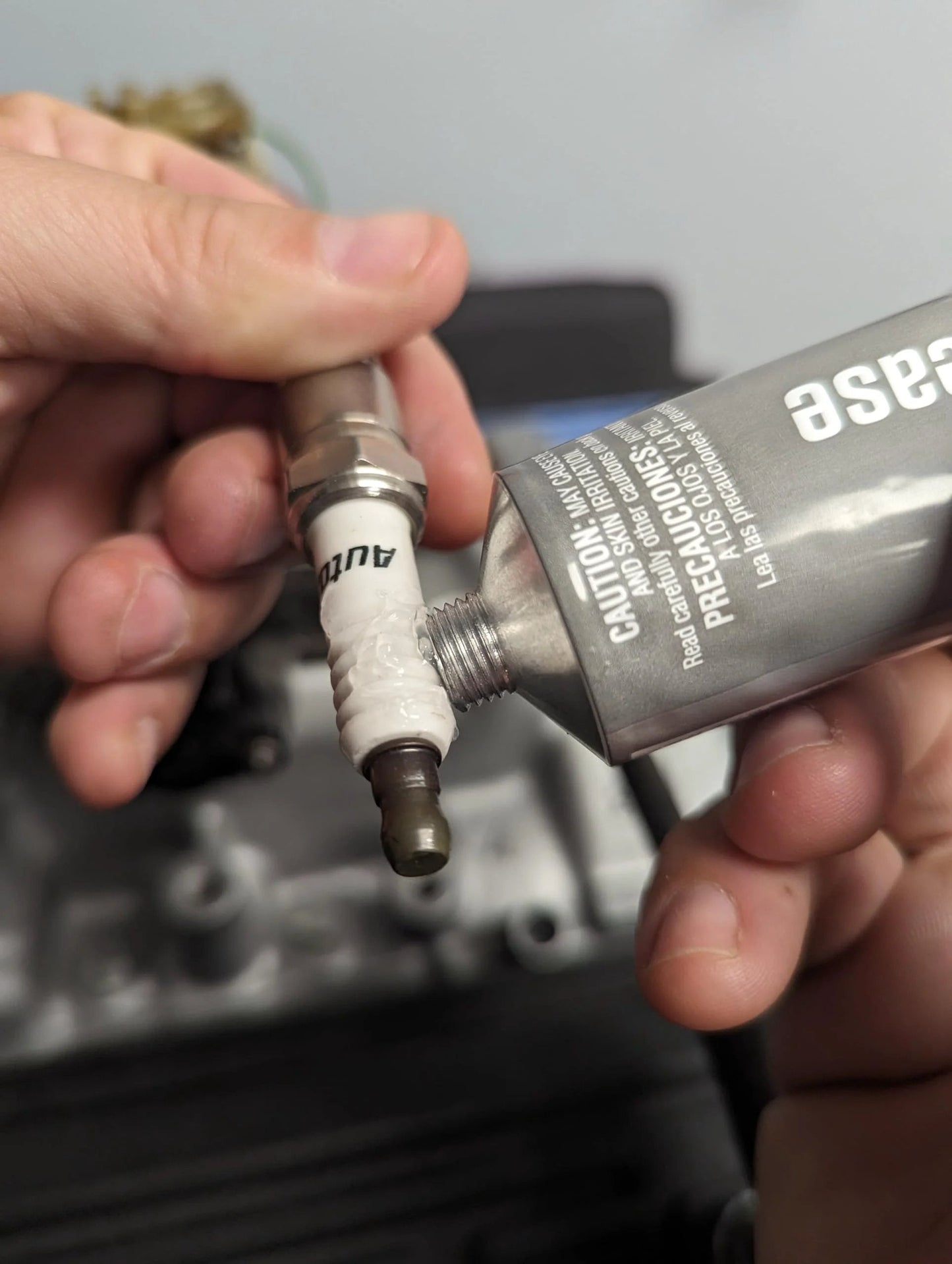 Applying Dielectric Tune Up Grease For Electrical Connections And Wiring 3oz to a spark plug for protection against corrosion.