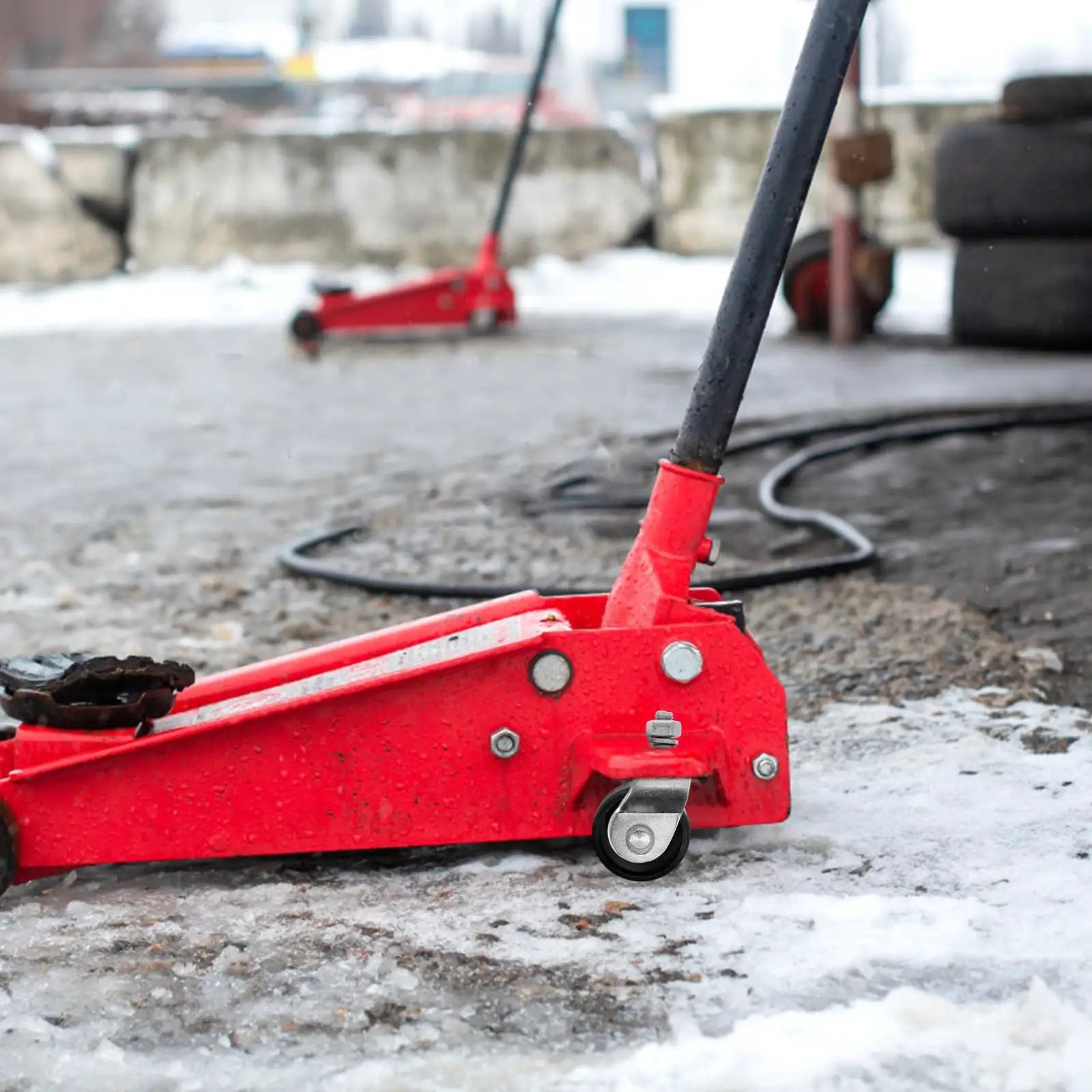 Close-up of 2 Ton Floor Jack Caster for Heavy Duty Garage Use with Hydraulic Front Wheel Replacement on concrete surface.