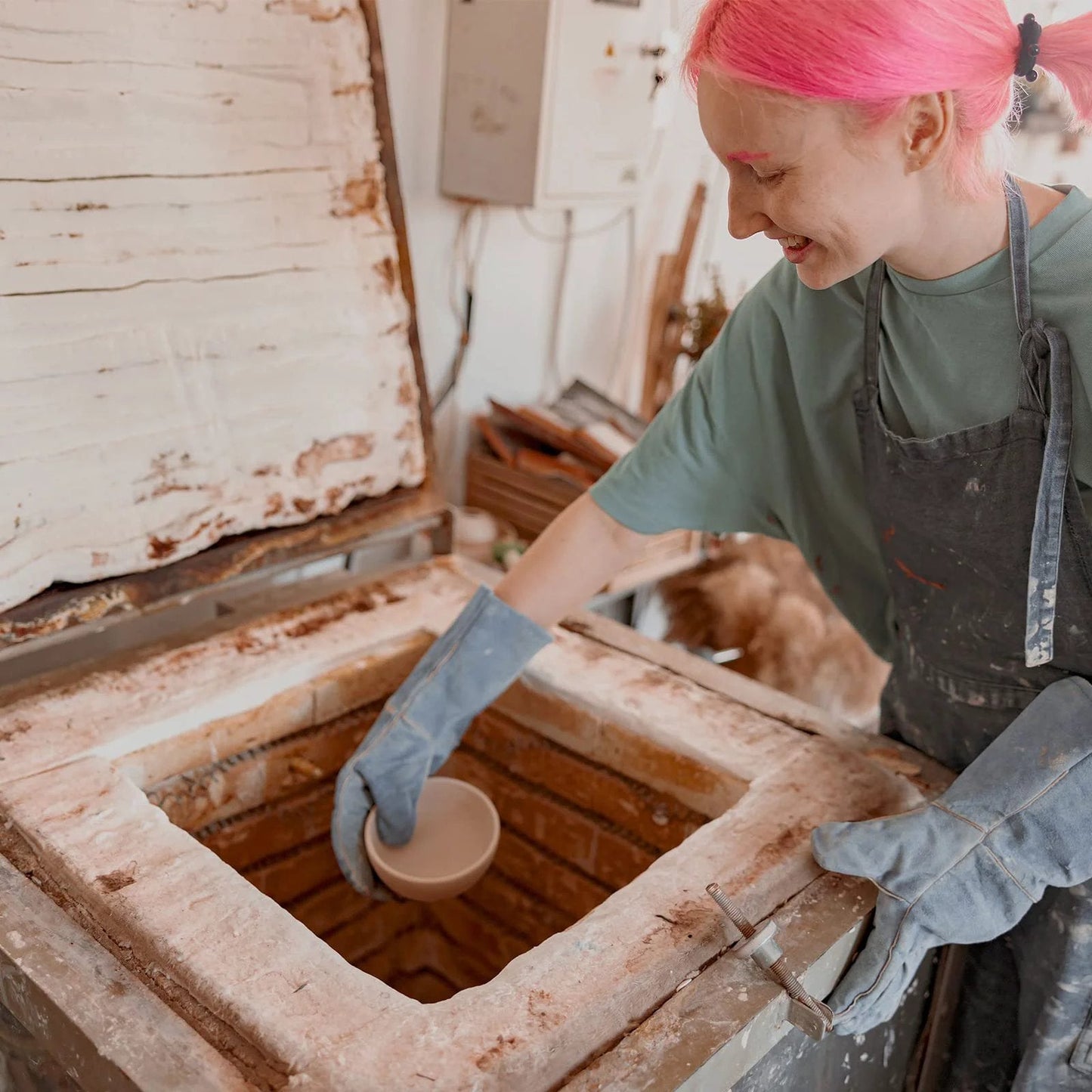 Person installing ceramic piece into kiln with 2 Pack Ceramic Fiber Insulation Blanket High Density 2400F Fireproof for Furnace use