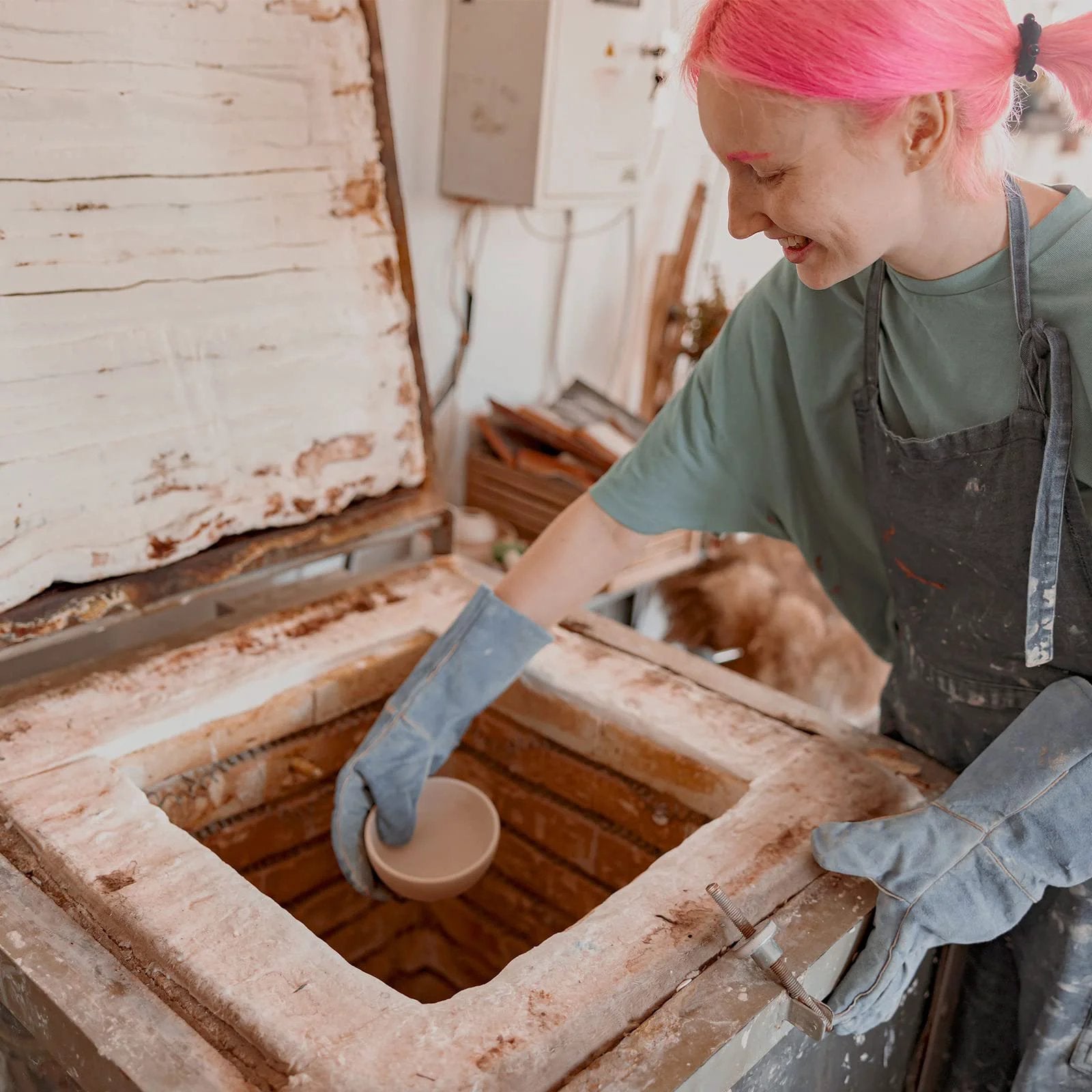 Person installing ceramic piece into kiln with 2 Pack Ceramic Fiber Insulation Blanket High Density 2400F Fireproof for Furnace use