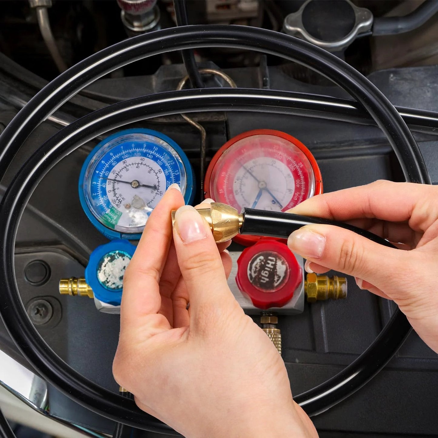 Close-up of hands using Six Piece Silicone Vacuum Hose Kit With Five Foot Lengths In One Eighth Inch, Five Thirty Second Inch, Three Sixteenth Inch, One Quarter Inch, Five Sixteenth Inch And Three Eighth Inch For High Temp Water Air Transfer And Vehicle Radiator Use By ZAVOOS with pressure gauges in the background