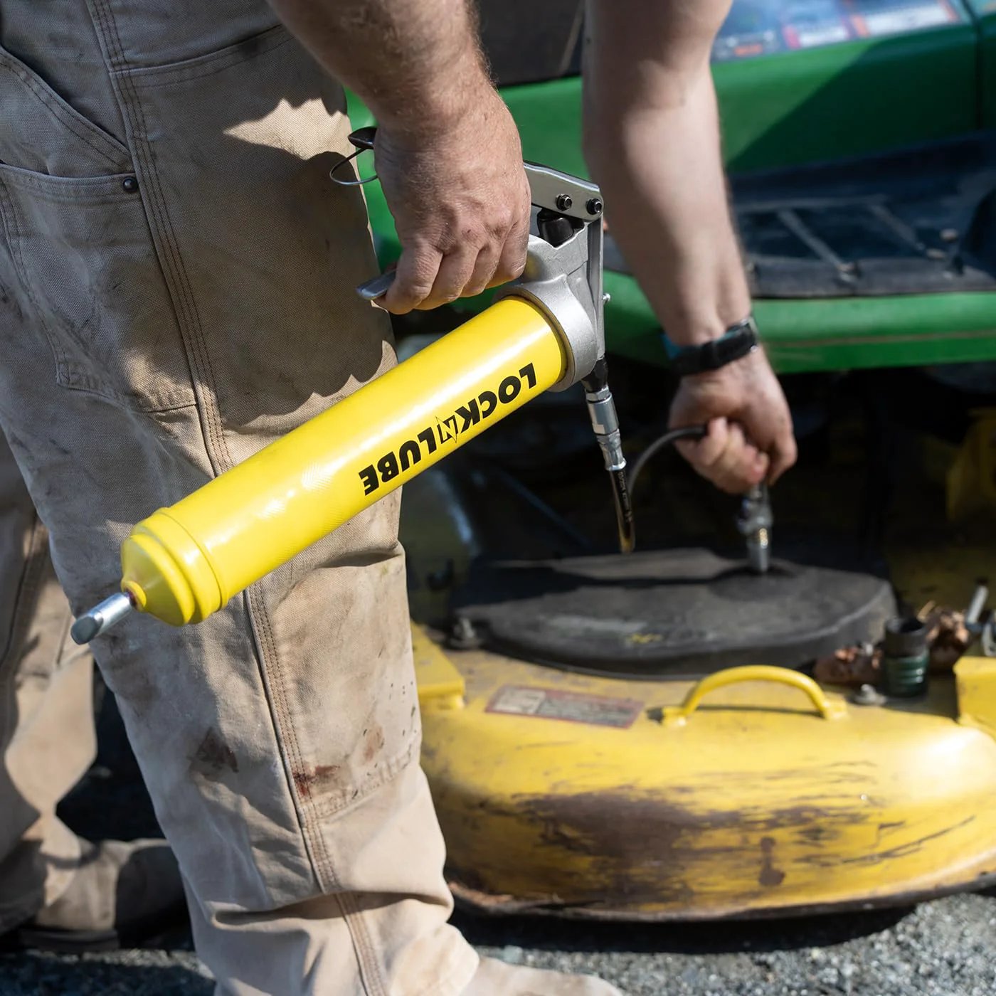 Person using Premium Pistol-Grip Grease Gun With LockNLube Coupler, 20 Inch Hose And Inline Swivel, Delivers Up To 8000 PSI