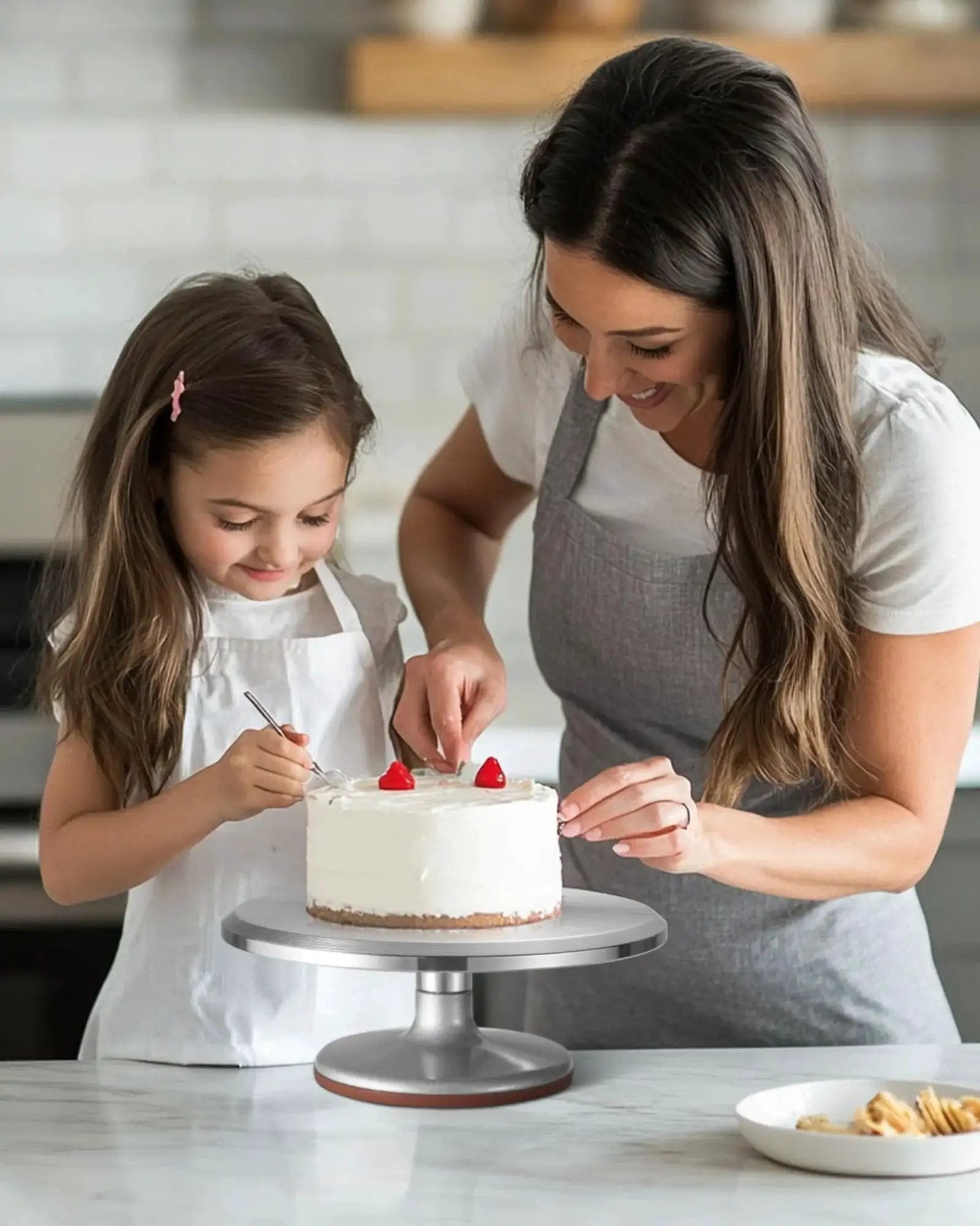 Mother and daughter decorating cake on 12 Inch Aluminum Alloy Rotating Cake Turntable With Non Slip Silicone Bottom Pro Grade Heavy Duty Revolving Cake Stand For Decorating Cakes, Pastries, And Cupcakes, Quiet Smooth Spin, Durable Kitchen Accessory For Bakers.