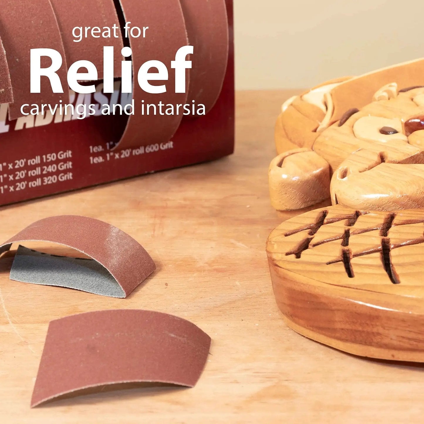 Emery Cloth Roll Sandpaper Dispenser With Pro Grade Boxed Multi Roll Tear Off Design shown with wooden carvings
