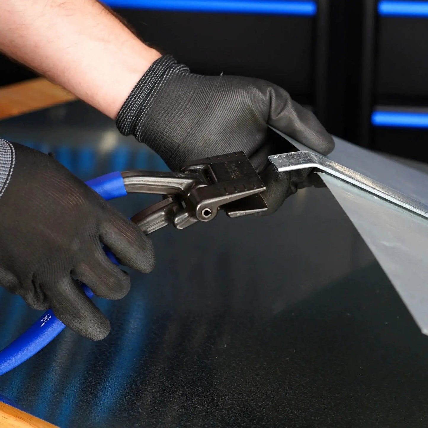 Person using Offset 3 Inch Seamer Tong For Sheet Metal Bending And Forming With One And Quarter Inch Throat Depth Ideal For HVAC Auto Repair And Home Improvement Midwest Made In USA MWT ST2 And Durable Build to bend metal sheet on workbench.