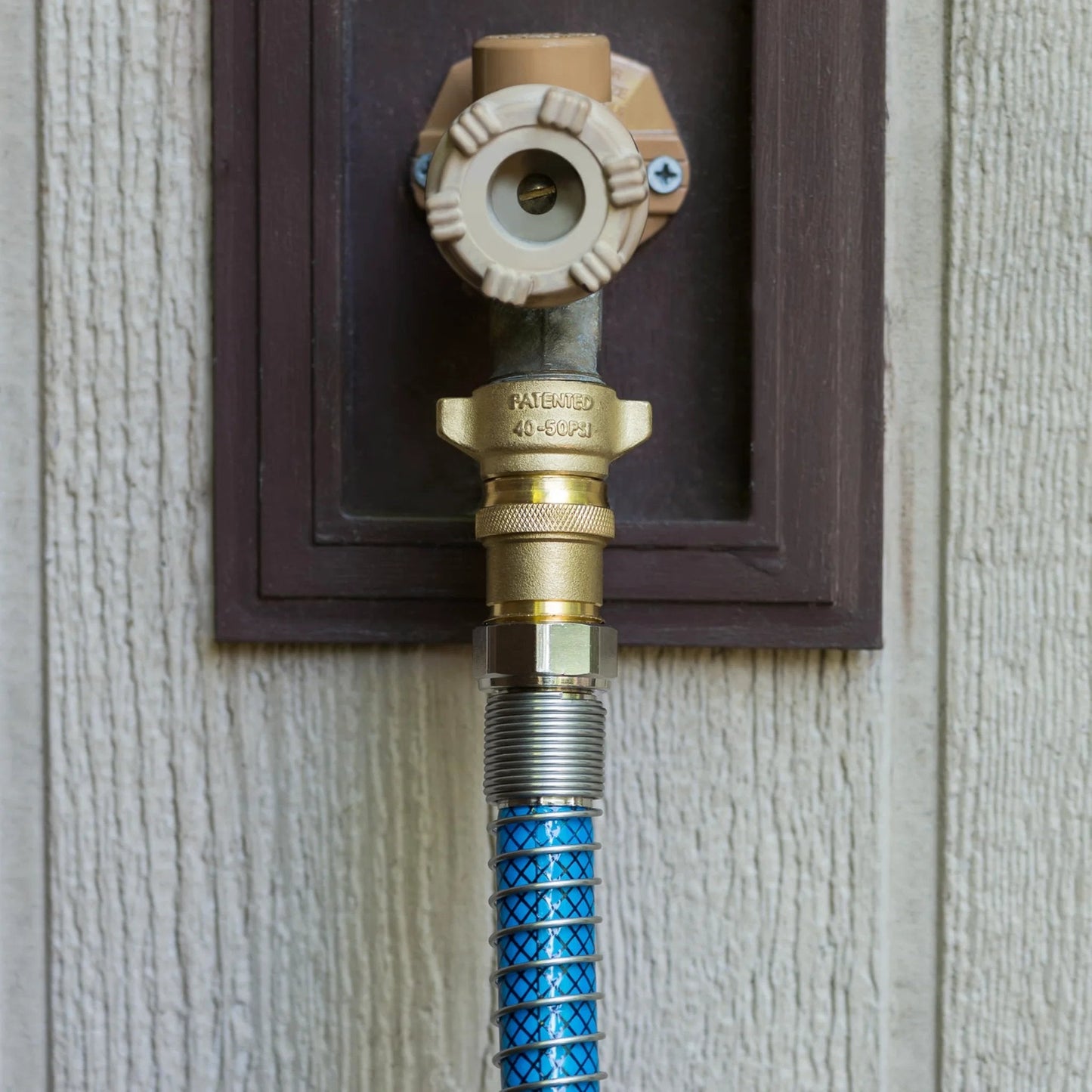 Brass RV Water Pressure Regulator For Safe 40 To 50 PSI Keeps Hoses Plumbing And Small Appliances In Check On Campers And Boats Drinking Water Safe Durable Camco installed on wall.