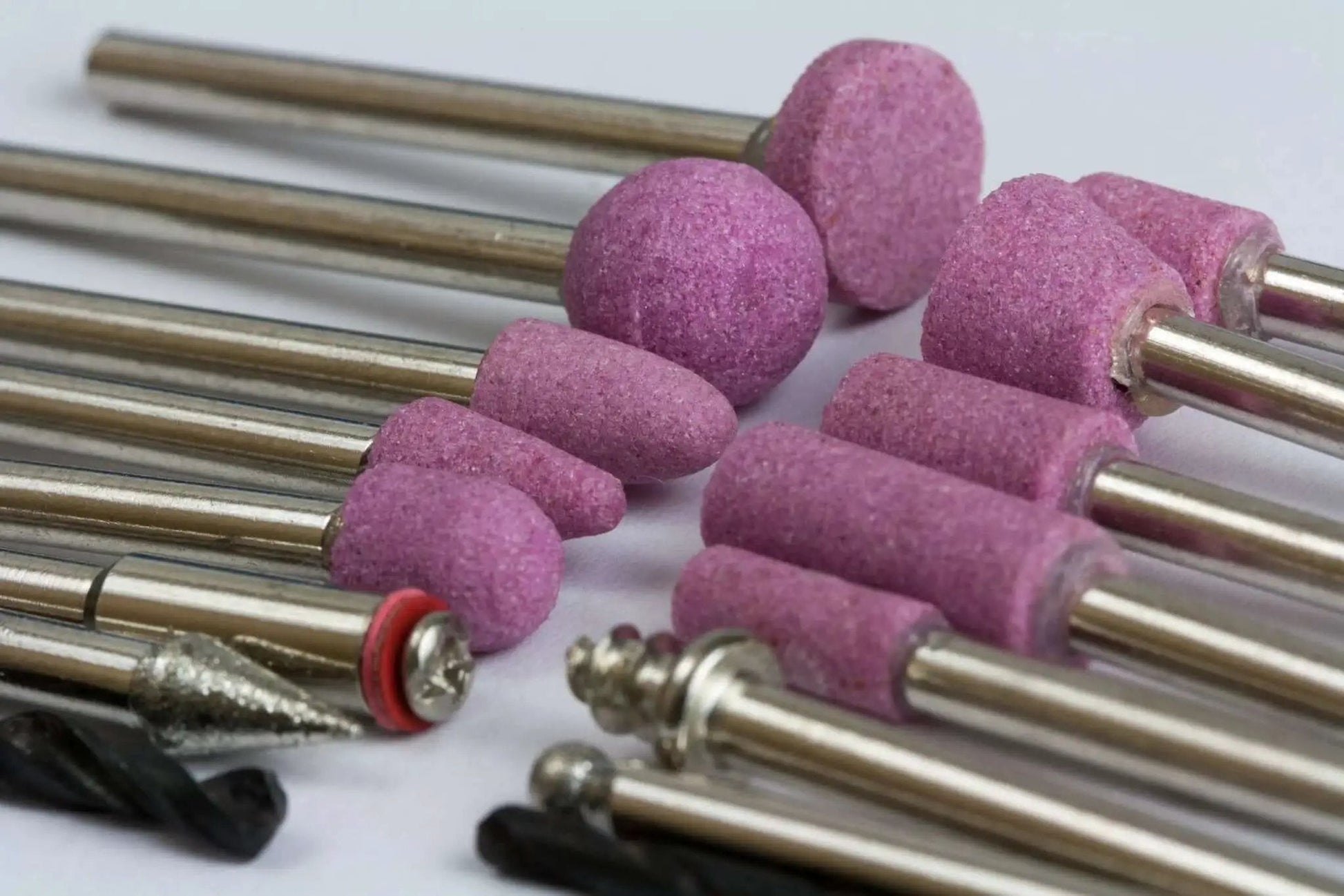 Close-up of accessory bits for All Purpose Rotary Tool Kit With Flex Shaft From WEN, 80 Piece Accessory Set, showing various grinding attachments.
