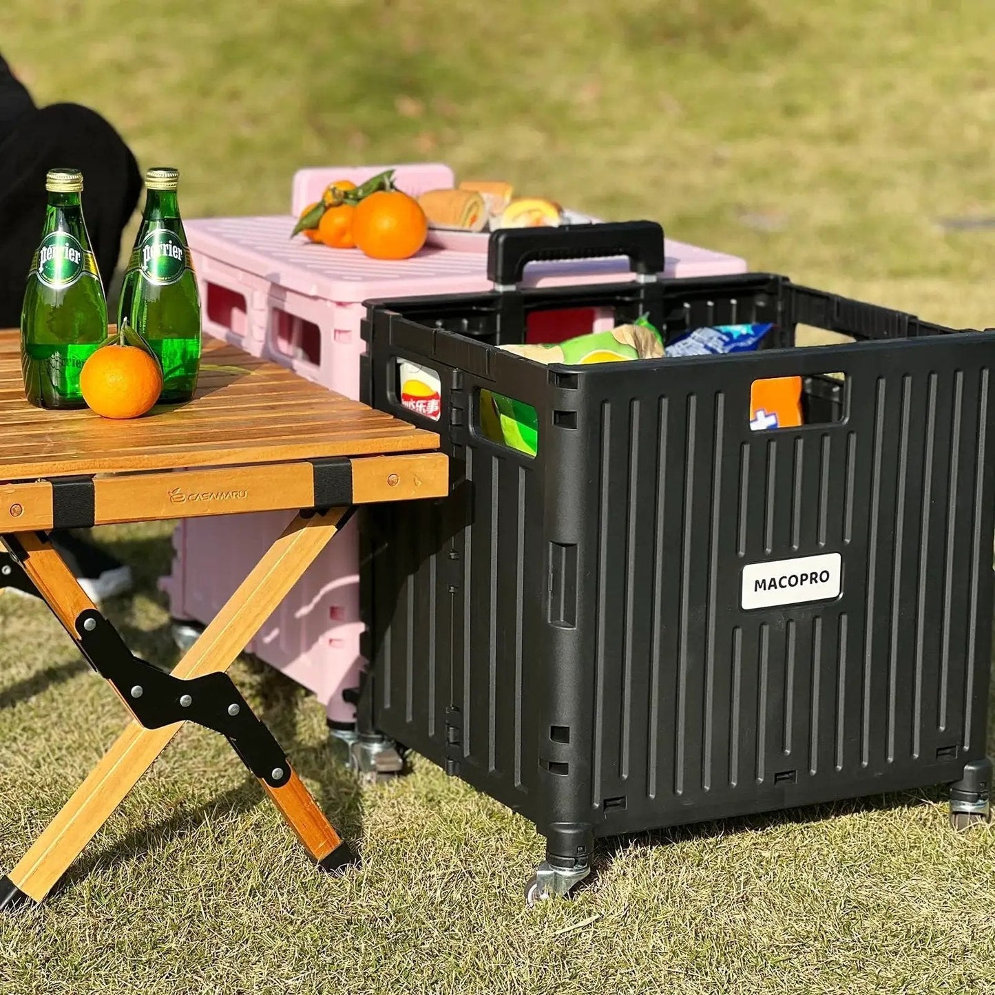 Folding Utility Cart With Lid And Basket On Four 360 Degree Rotating Wheels in use outdoors next to a wooden table with drinks and oranges