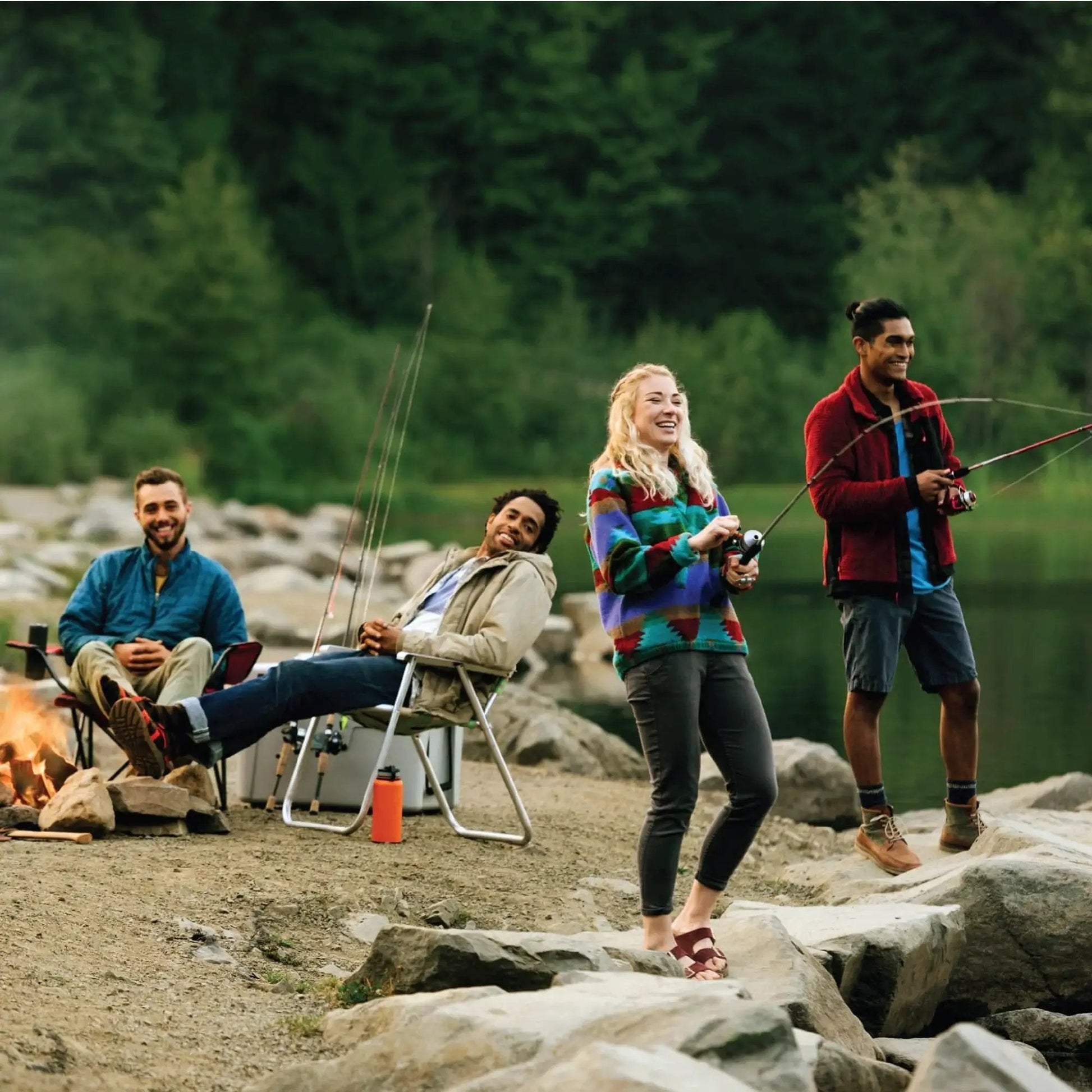 Group of people fishing at a lakeside with camping gear, holding Zebco Bullet Spincast Fishing Reel, joyful and relaxed.
