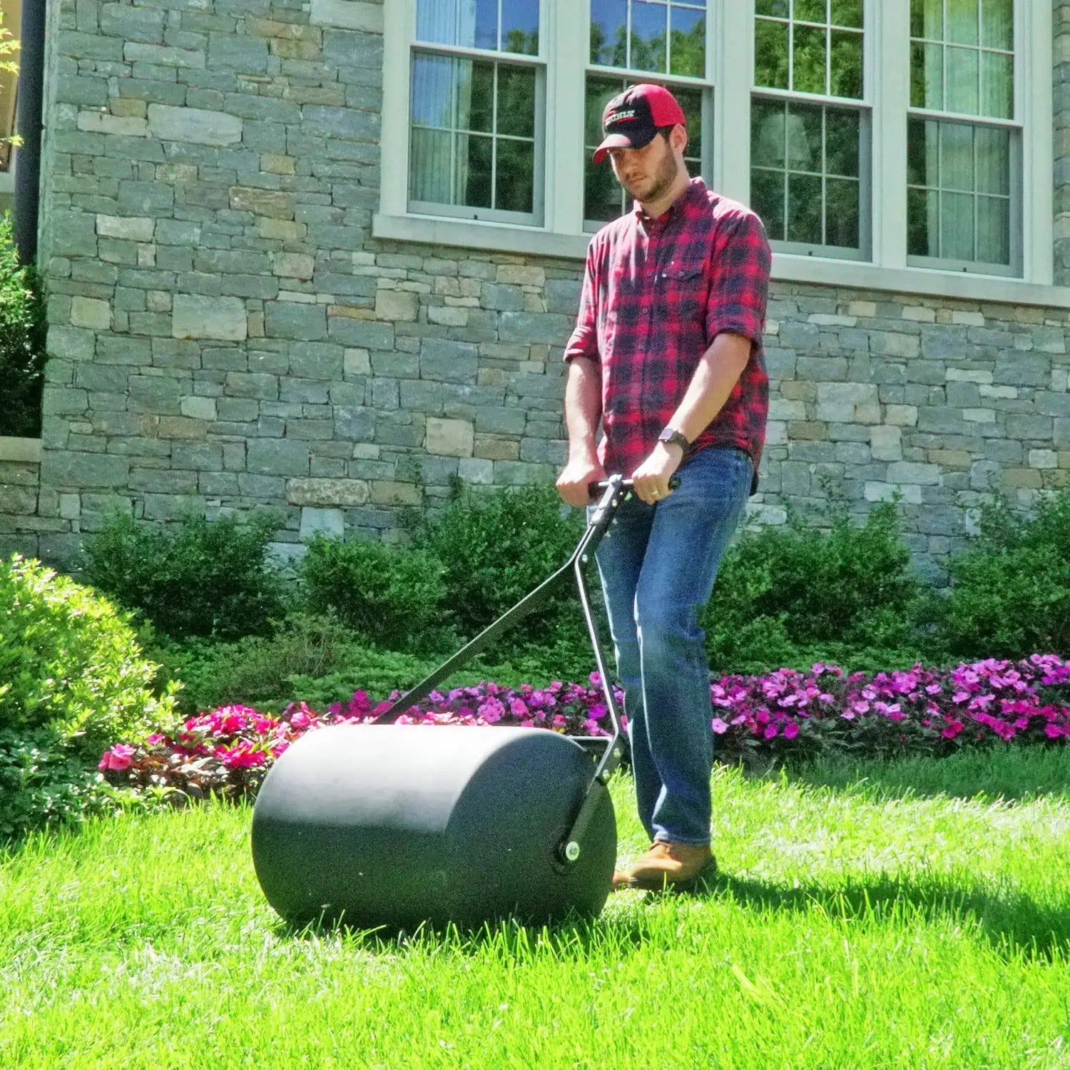 Man using Powerful 270 Lb Poly Lawn Roller For Push Or Tow With Easy Turn Tethered Plug And Quick Filling Drum 18 By 24 Inches