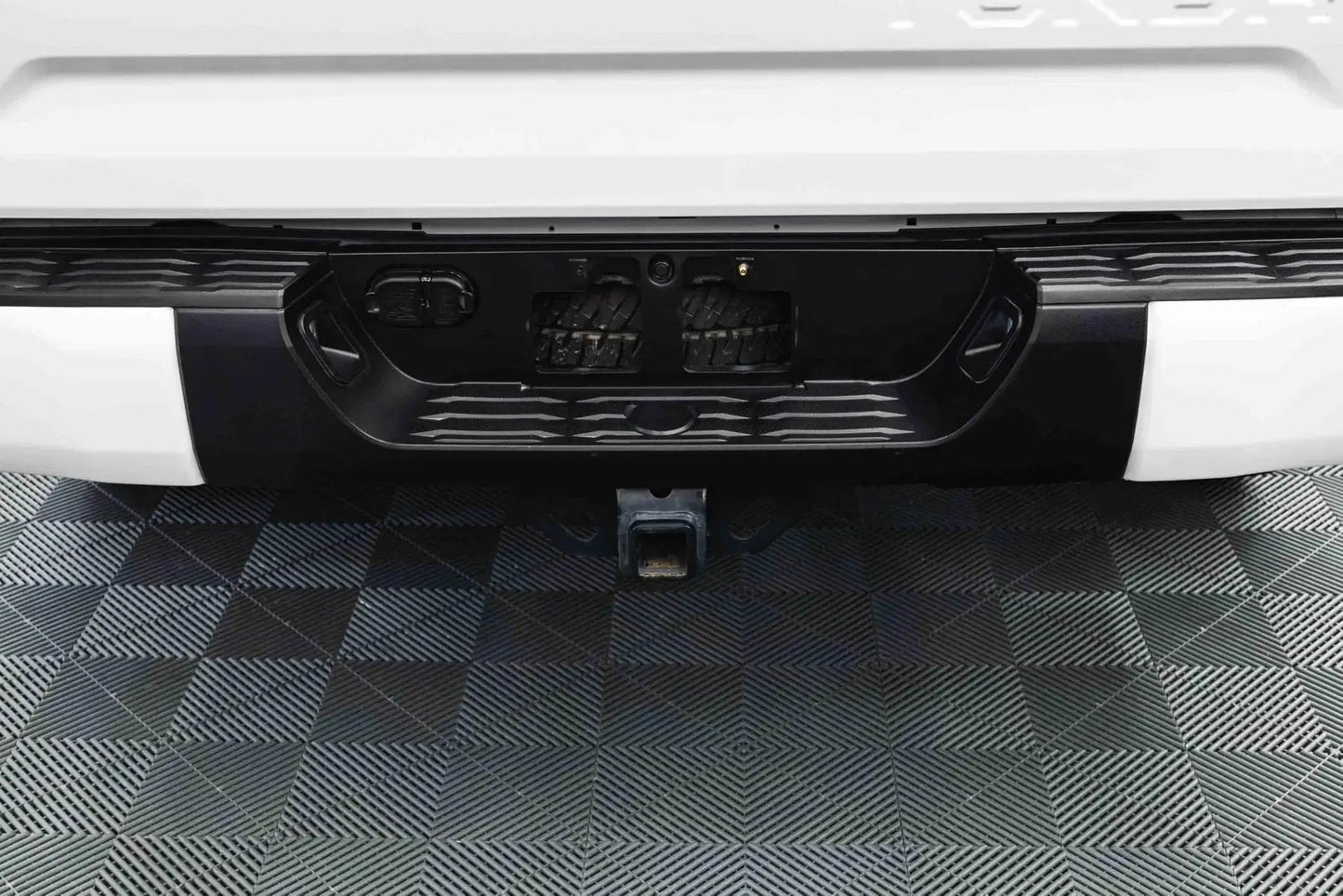 Rear vehicle bumper treated with Trim And Exterior Plastic Restorer With UV Protection Up To 2 Years 50 Ml, close-up view.