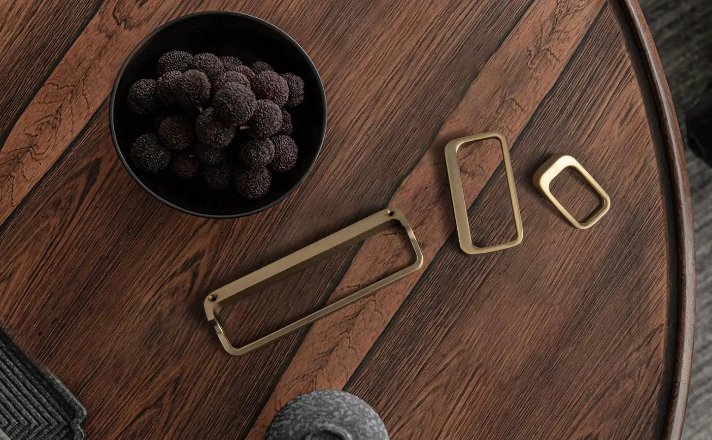 Champagne Bronze Cabinet Pulls With Center Hole 5 Inch Length Modern Zinc Finger Handles for drawers and cupboards on a wooden surface