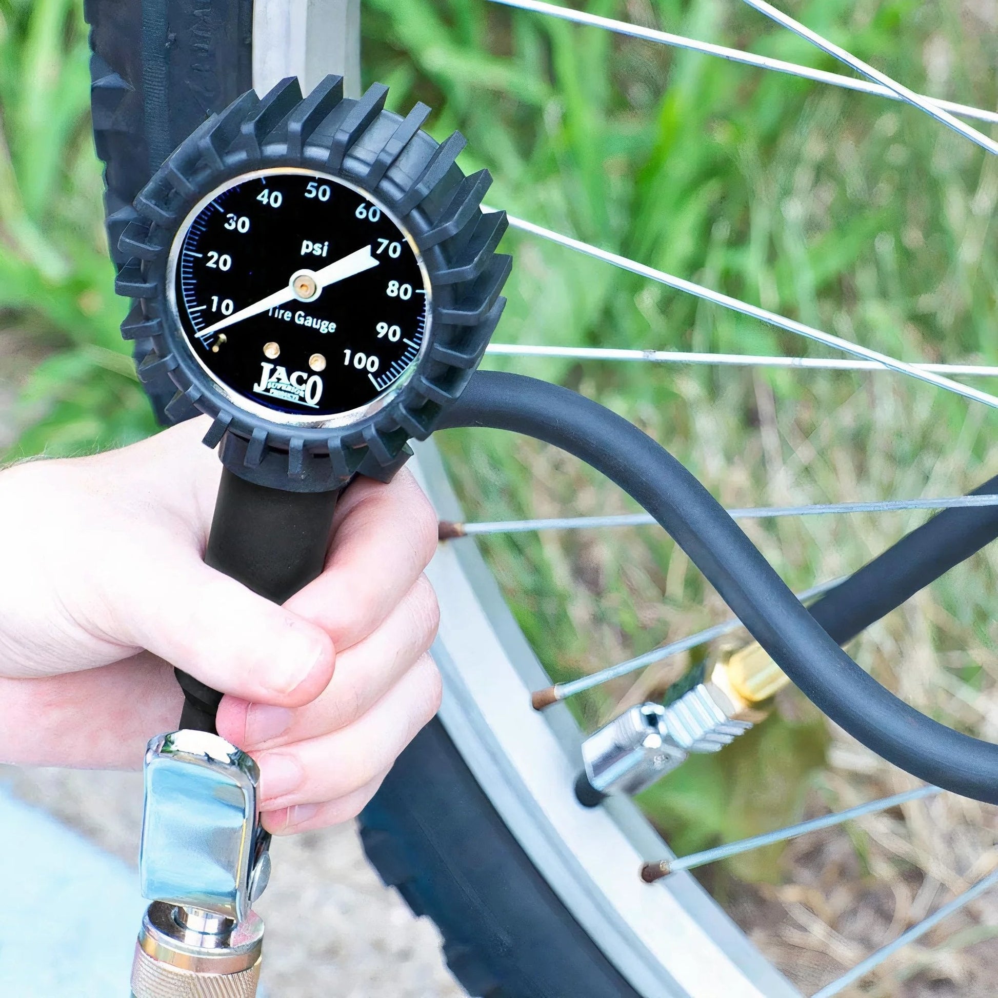 FlowPro Tire Inflator With Pressure Gauge Up To 100 PSI Mechanical Tire Pump used on a bicycle wheel, showing night glow dial.