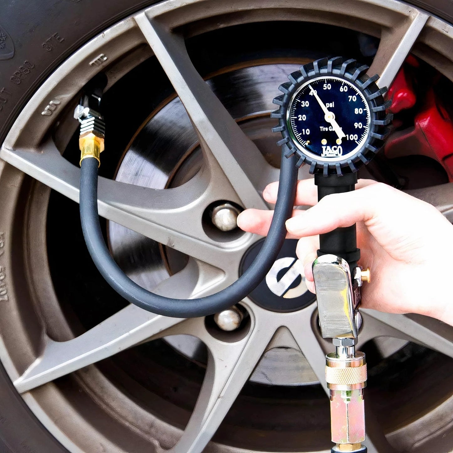 FlowPro Tire Inflator With Pressure Gauge Up To 100 PSI Mechanical Tire Pump used on car wheel, night glow dial visible.