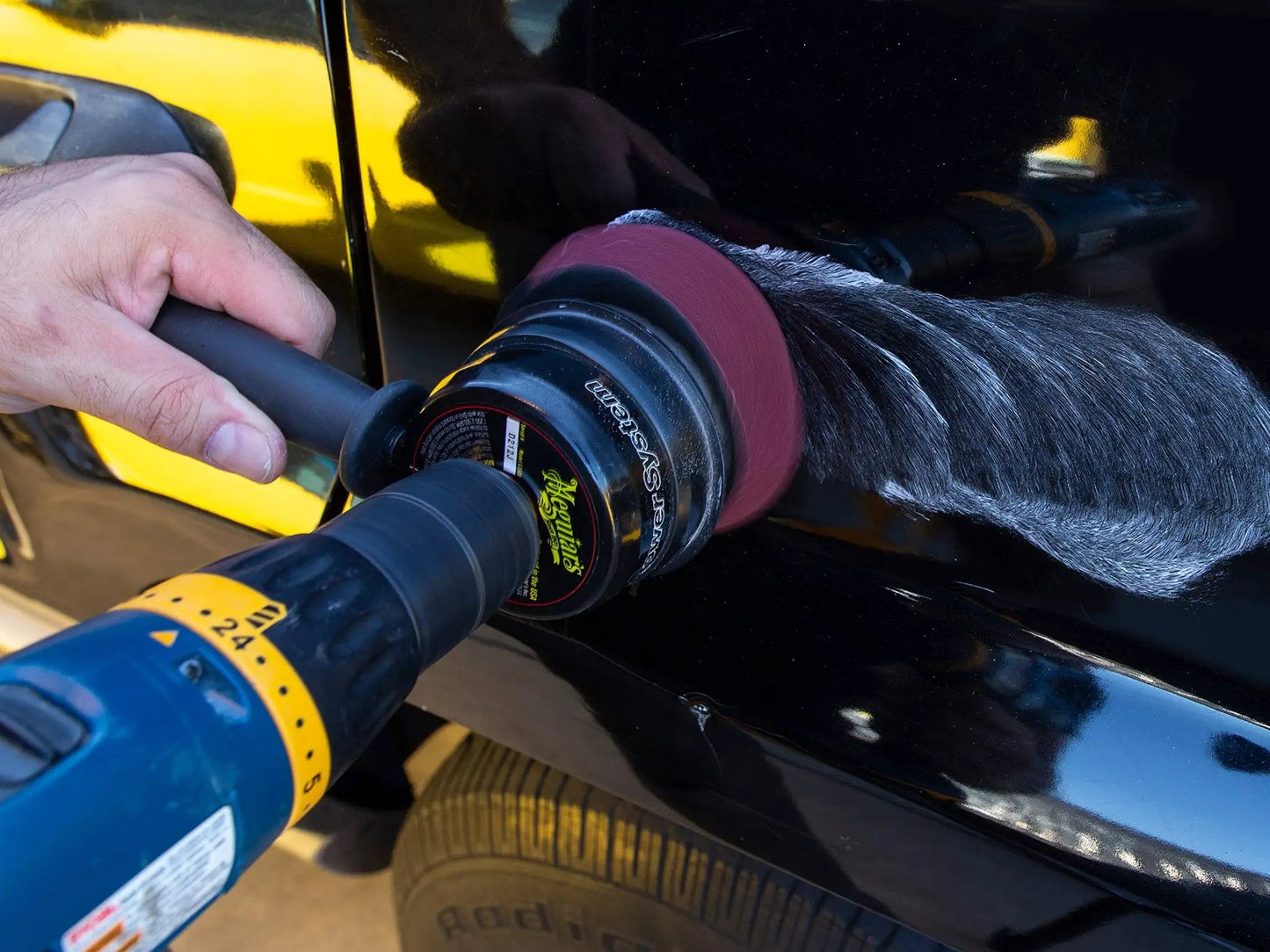 Close-up of using Meguiars ScratchX 2.0 G10307C scratch remover with a polisher on car paint.