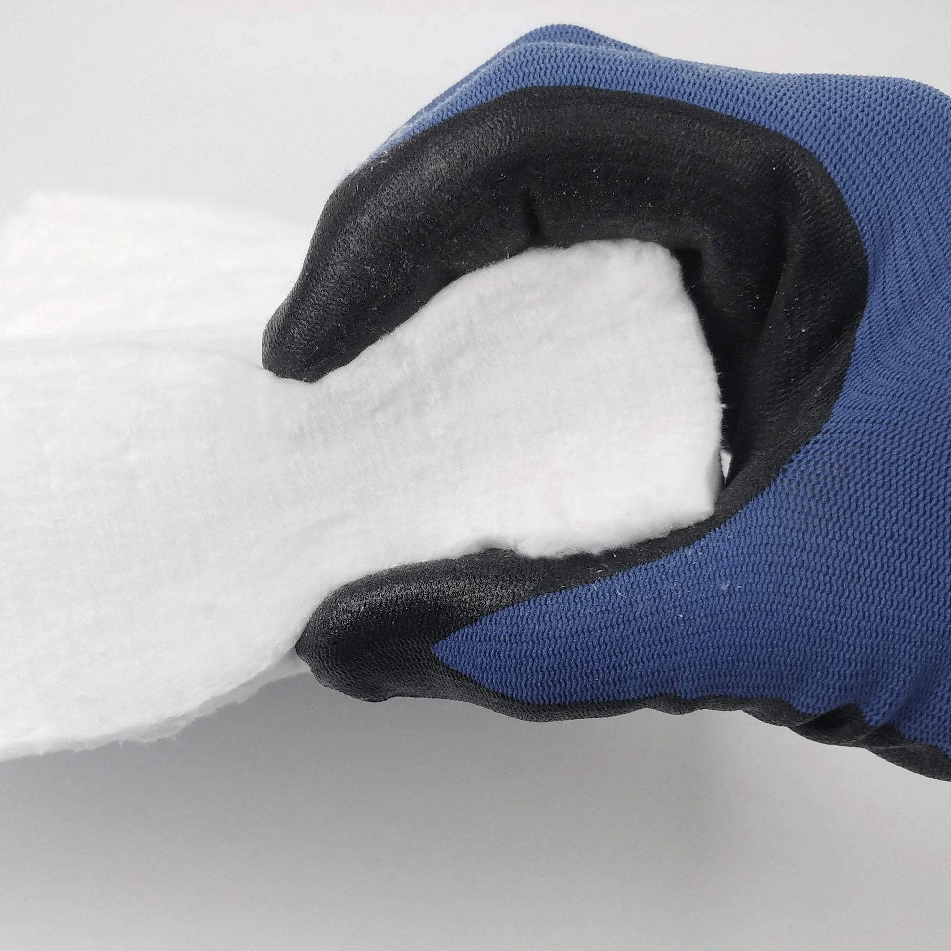 Gloved hand holding Heavy Duty Ceramic Fiber Insulation Blanket 2 Inch Thick By 15 By 24 In 2400 F Fireproof Heat Shield