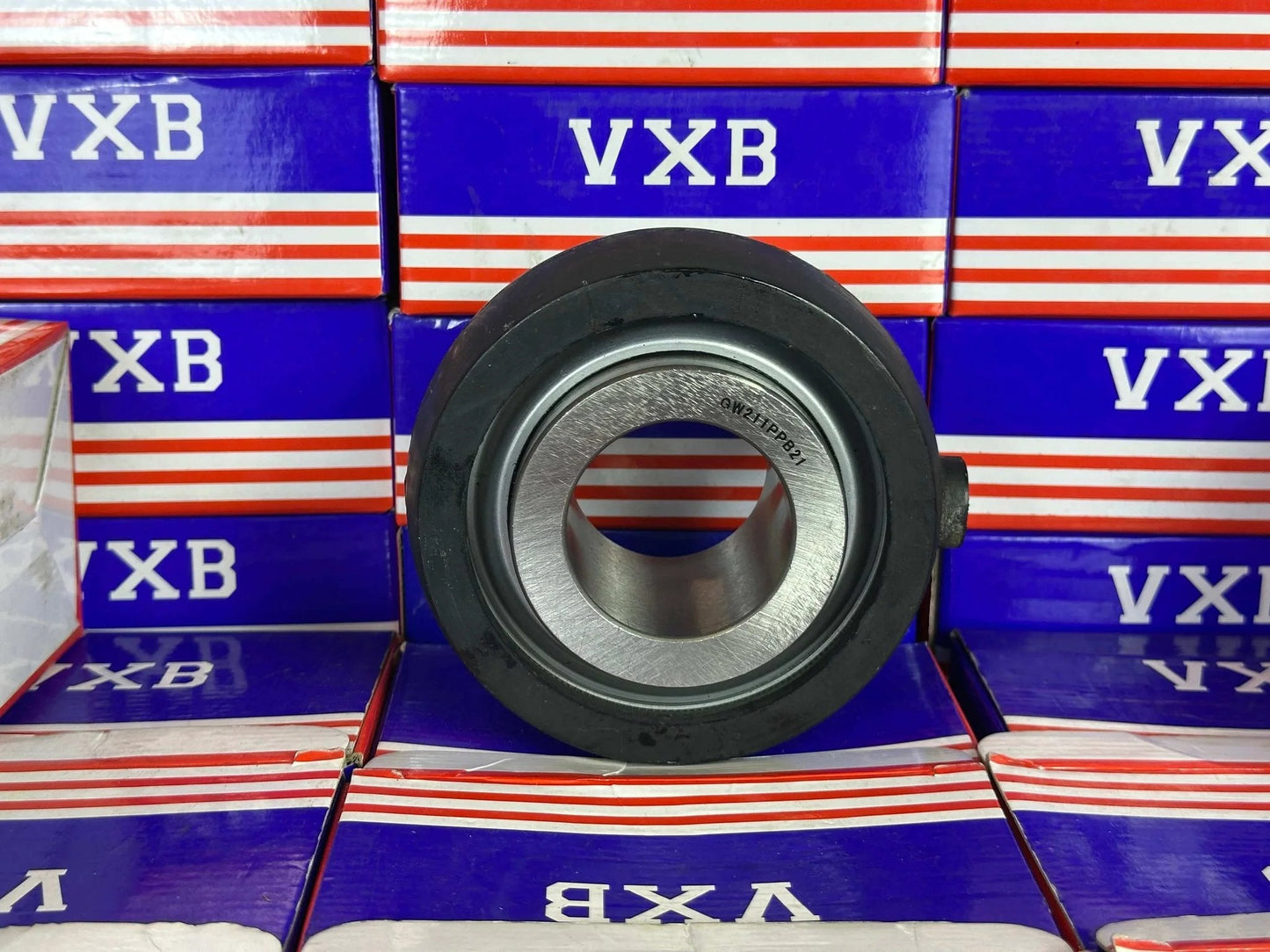 GW211PPB21 Agricultural Heavy Duty Bearing Round Bore Bearing with rubber shown from the front on a colorful background.