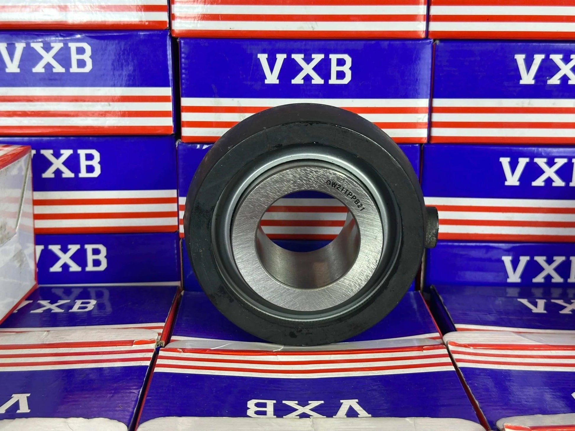GW211PPB21 Agricultural Heavy Duty Bearing Round Bore Bearing with rubber shown from the front on a colorful background.