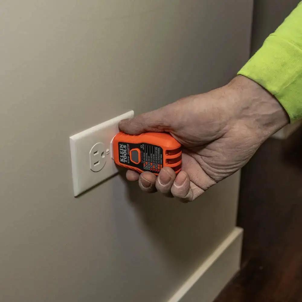 Hand using ET310KIT AC Circuit Breaker Finder Kit to test GFCI outlet with transmitter and receiver