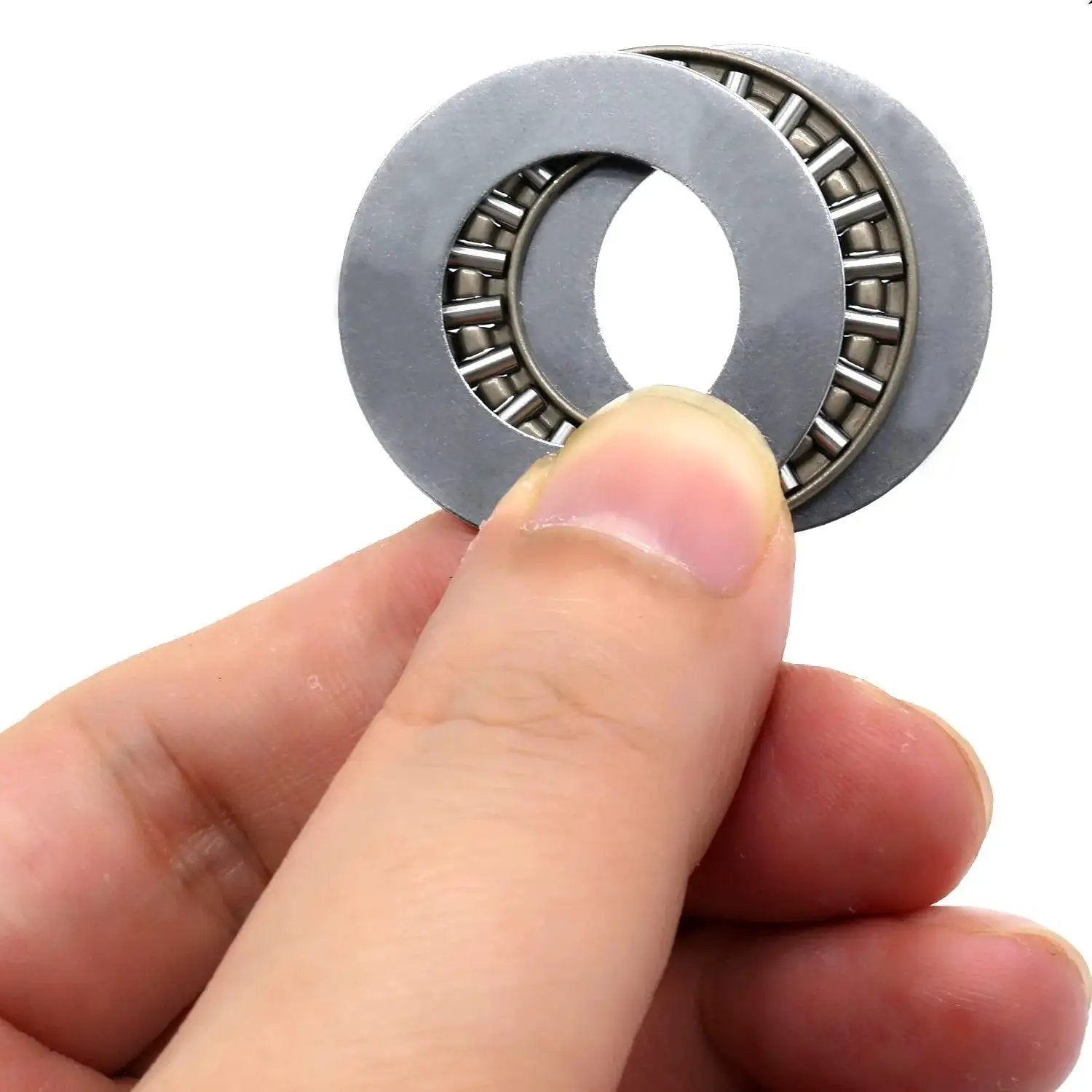 Close-up of Heavy Duty Workhorse Thrust Needle Roller Bearing Set With Washers AXK2035 held in hand, showing precision steel cage.