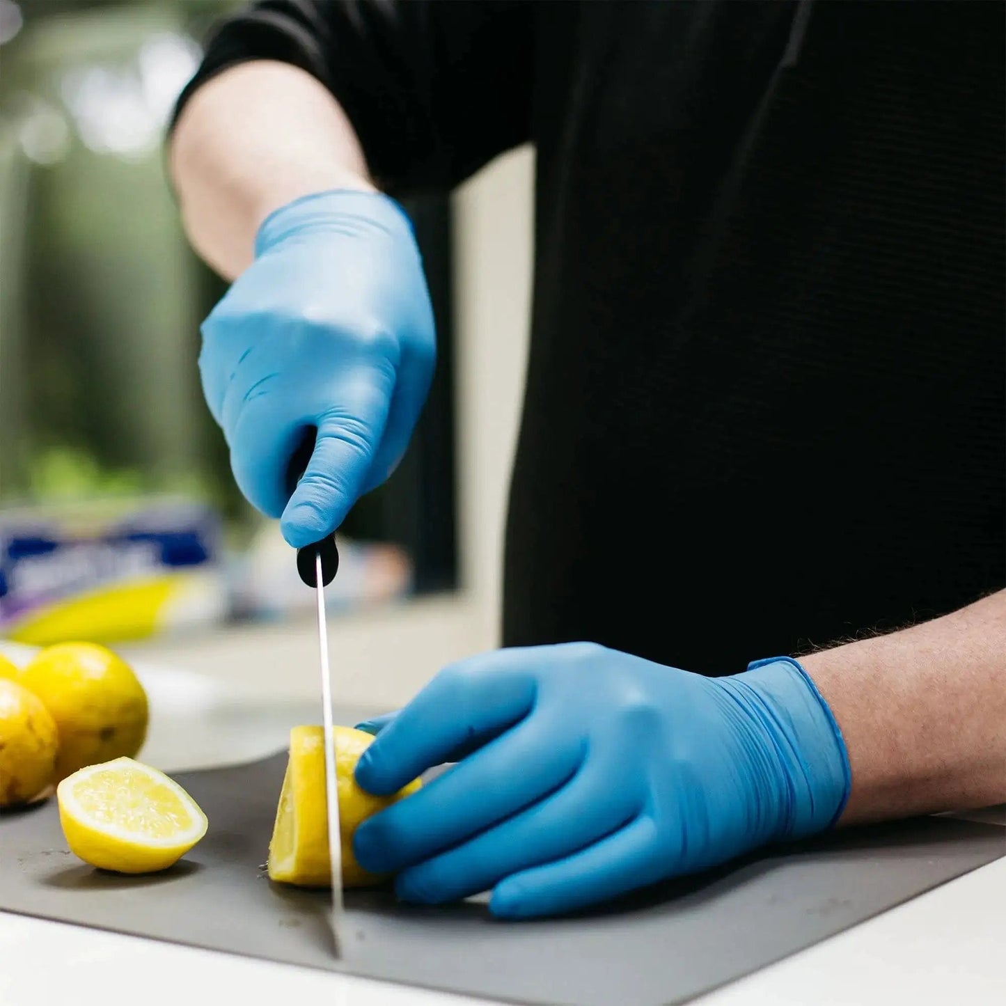 Person wearing Blue Nitrile Gloves 3 Mil Textured Large Latex Free Powder Free Box Of 100 cutting lemon