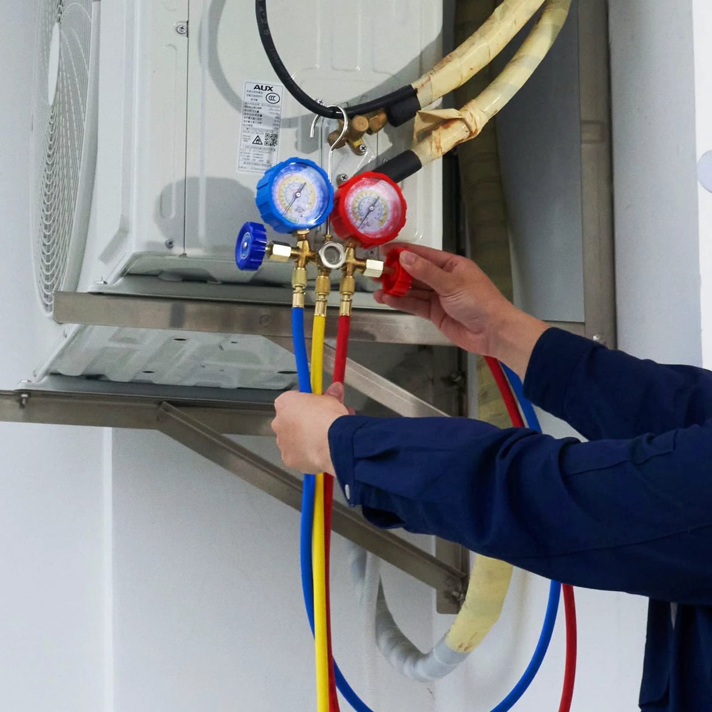 Person using Car AC Gauge Set With 3 Way Manifold And 5 Ft Hoses Couplers And Can Tap For R134A R22 R12 R502 Refrigerants for maintenance.