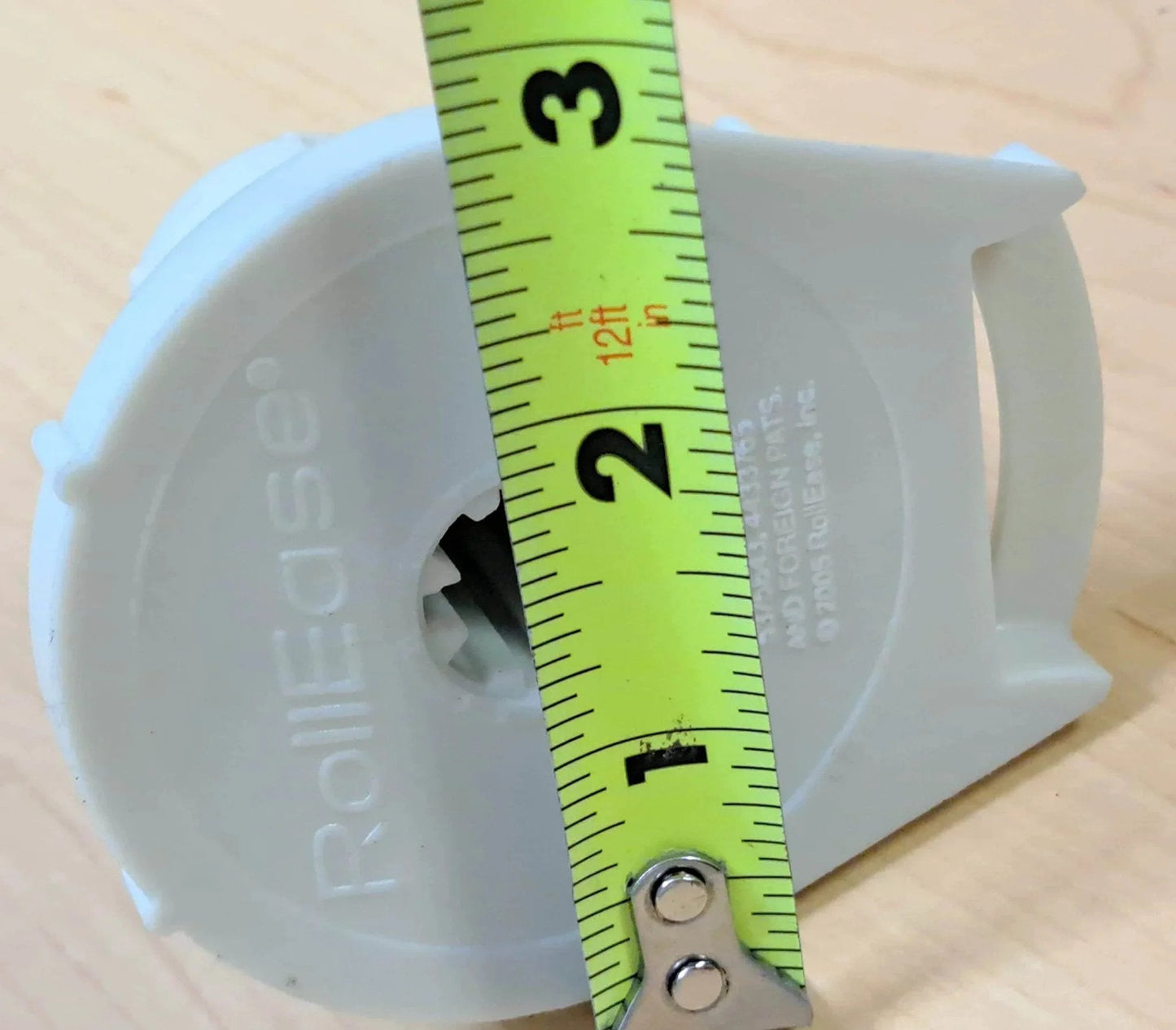 Front view of Clutch R Series with Bead Stopper (White, R16-1 1/2" Tube) next to measuring tape.