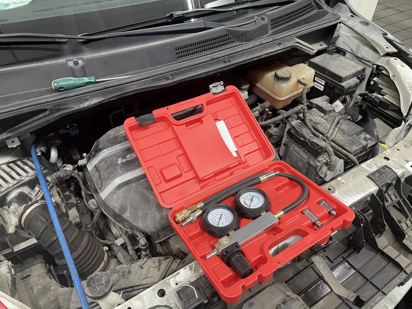 Go-To Cylinder Leak Detector And Engine Compression Test Kit For Piston Ring, Valve, And Head Gasket Diagnostics with gauges and hose in open case on engine