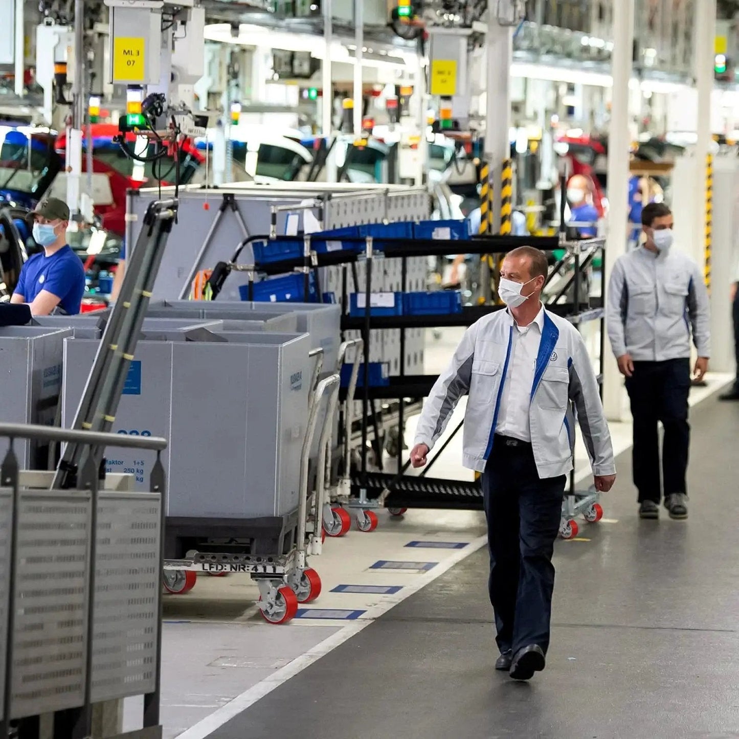 Factory workers in a production line wearing masks.