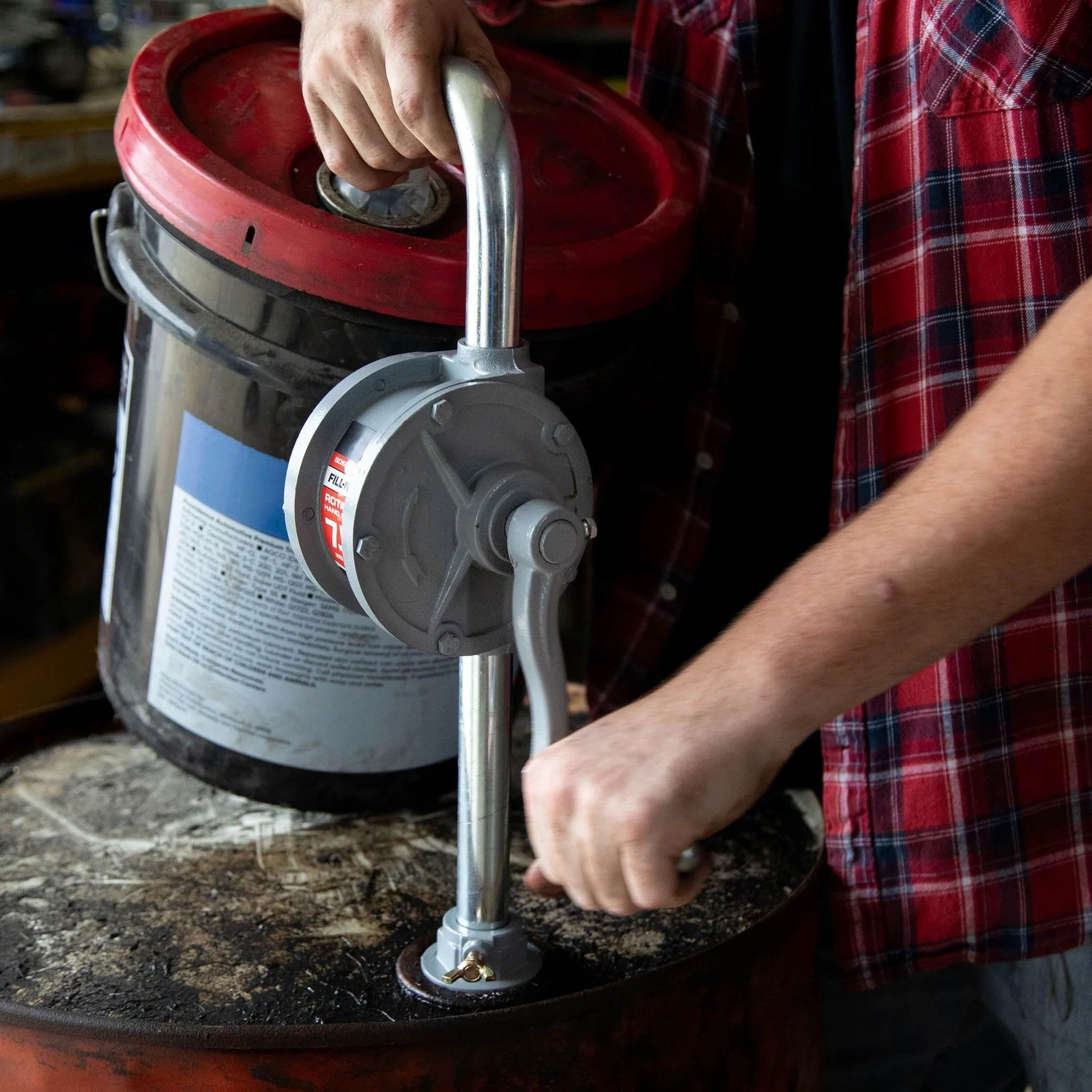 Person operating Fill-Rite SD62 Hand Pump Rotary 2-Vane Curved Spout on a drum