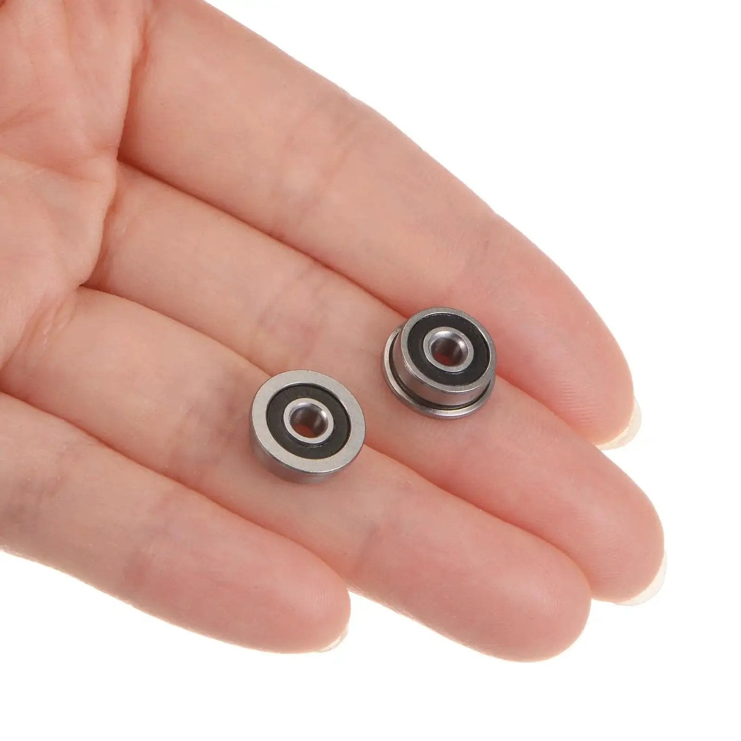 Two Flanged Ball Bearing 3x10x4mm F623 2RS Double Sealed held in a hand, showcasing chrome steel material.