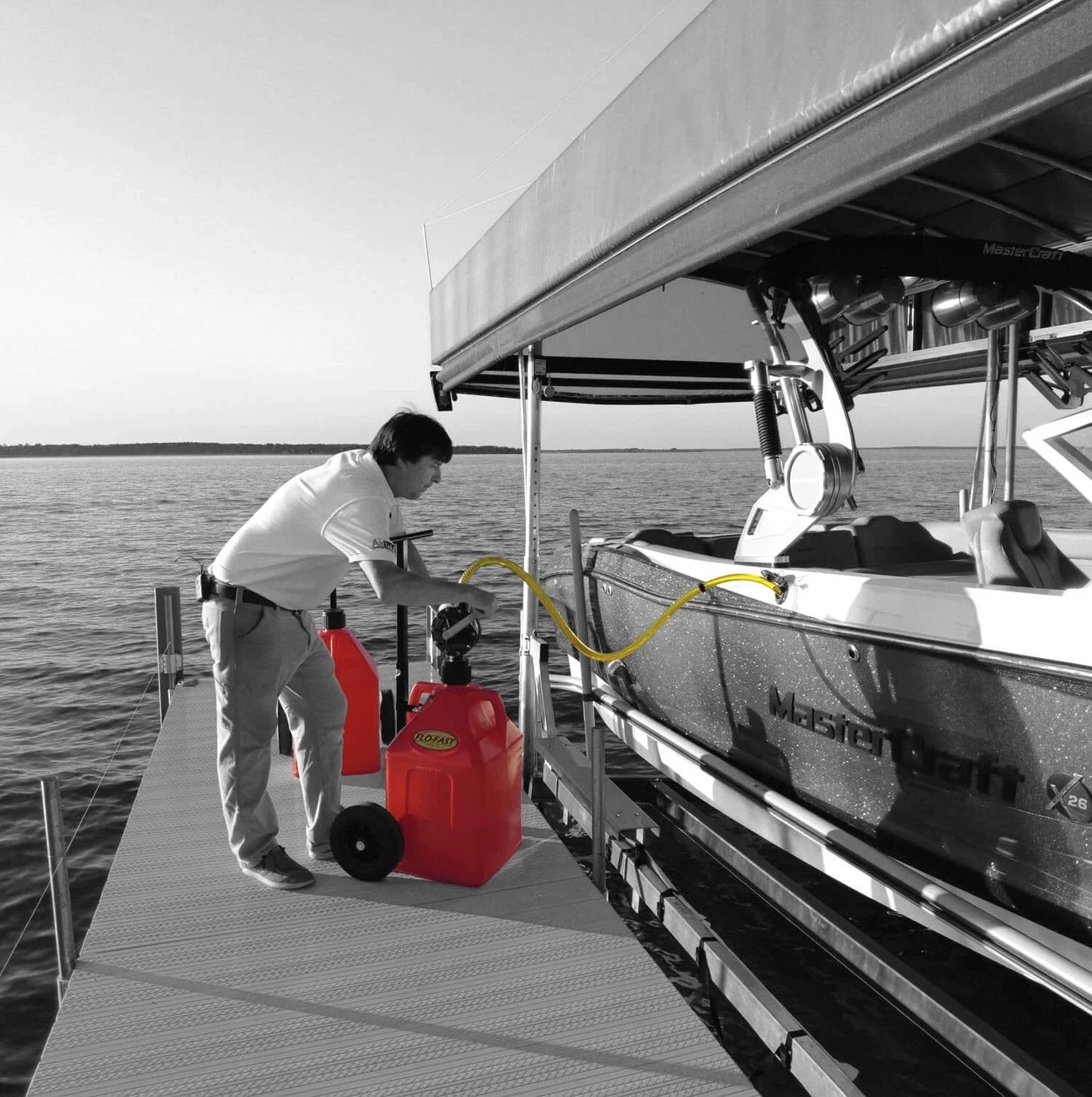 Person using FLO-FAST Pro Pump, 8GPM, Telescoping Draw Tube on dock, fits Containers and Barrels, Made in USA for Marine use