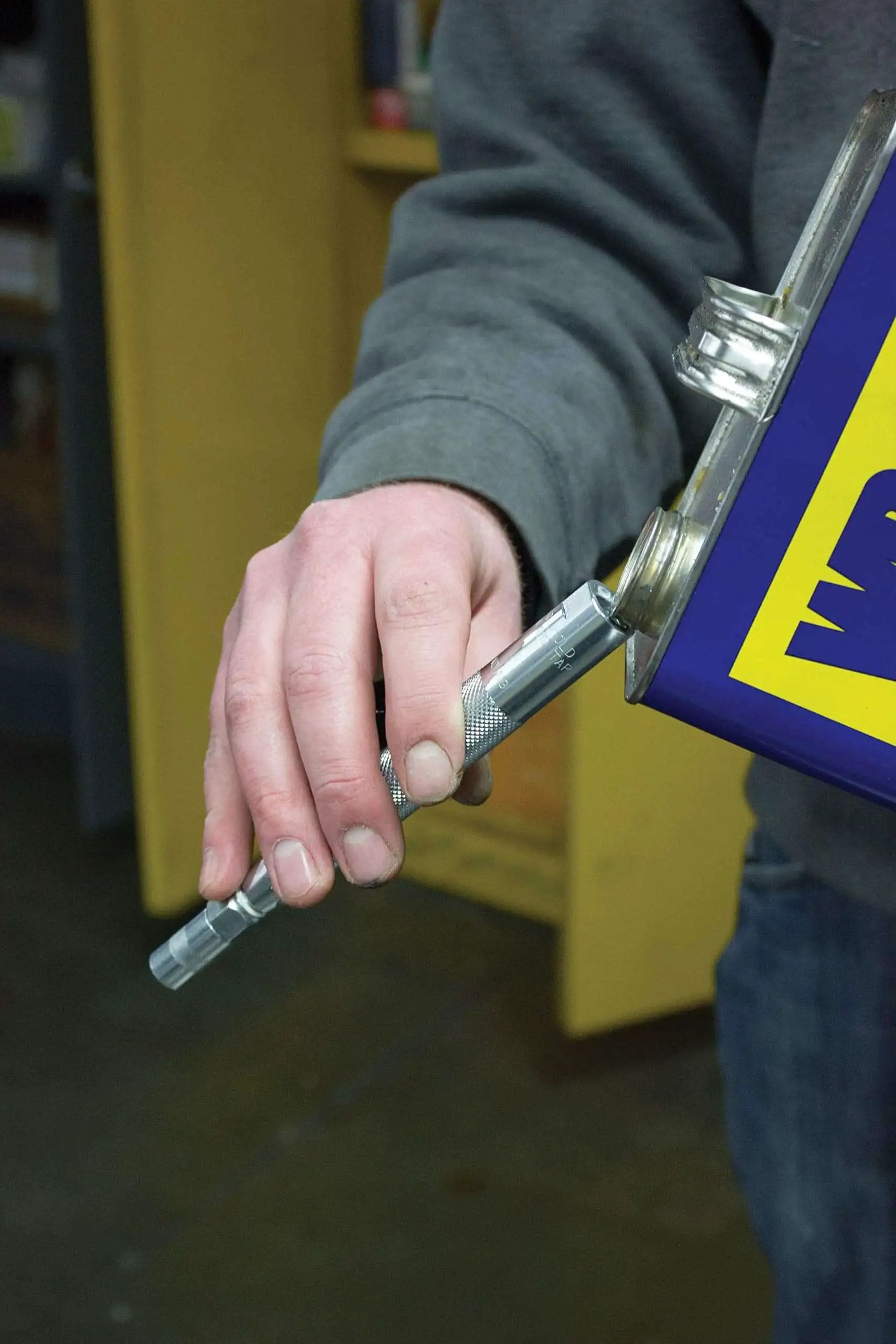 Man holding Grease Joint Rejuvenator Master Kit Large with Pro Model 7862 and Pocket Model 7864, 5-inch flex hose attachment visible
