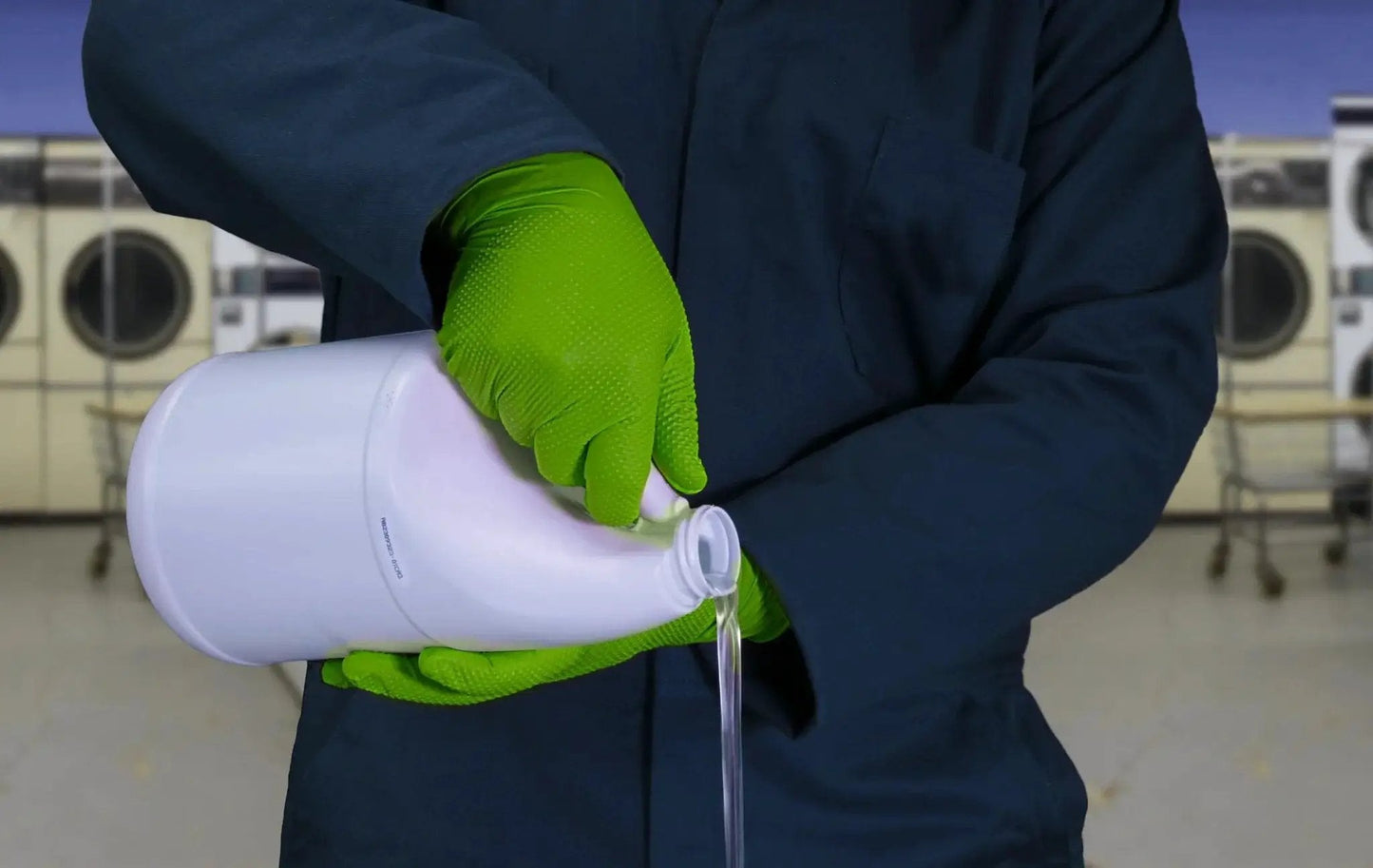 Person using Green Nitrile Latex Free Gloves 8 Mil Heavy Duty Raised Diamond Texture Box 100, pouring liquid detergent in laundry setting