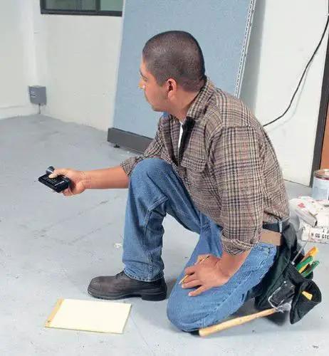 Man using Precision Handheld Ultrasonic Distance Meter For Fast Measurements With A 50 Foot Range That Quickly Displays Length Area And Volume In A Compact Unit Ideal For Painters Builders Flooring Pros And DIY Enthusiasts DM S50 in a room