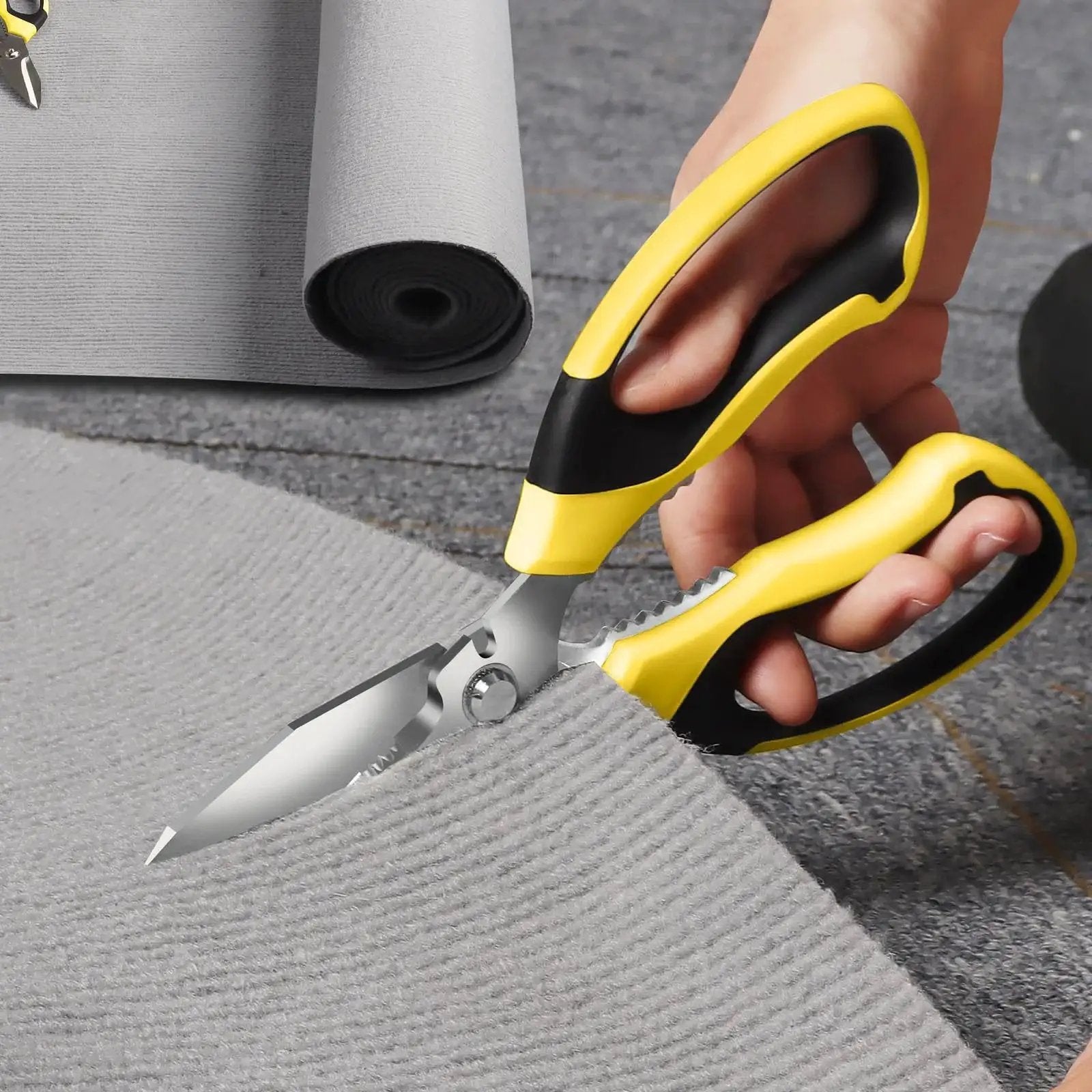 Heavy Duty 8 Inch Utility Scissors with Serrated Blades cutting gray carpet, showcasing ergonomic grip for multipurpose use in home or workshop.