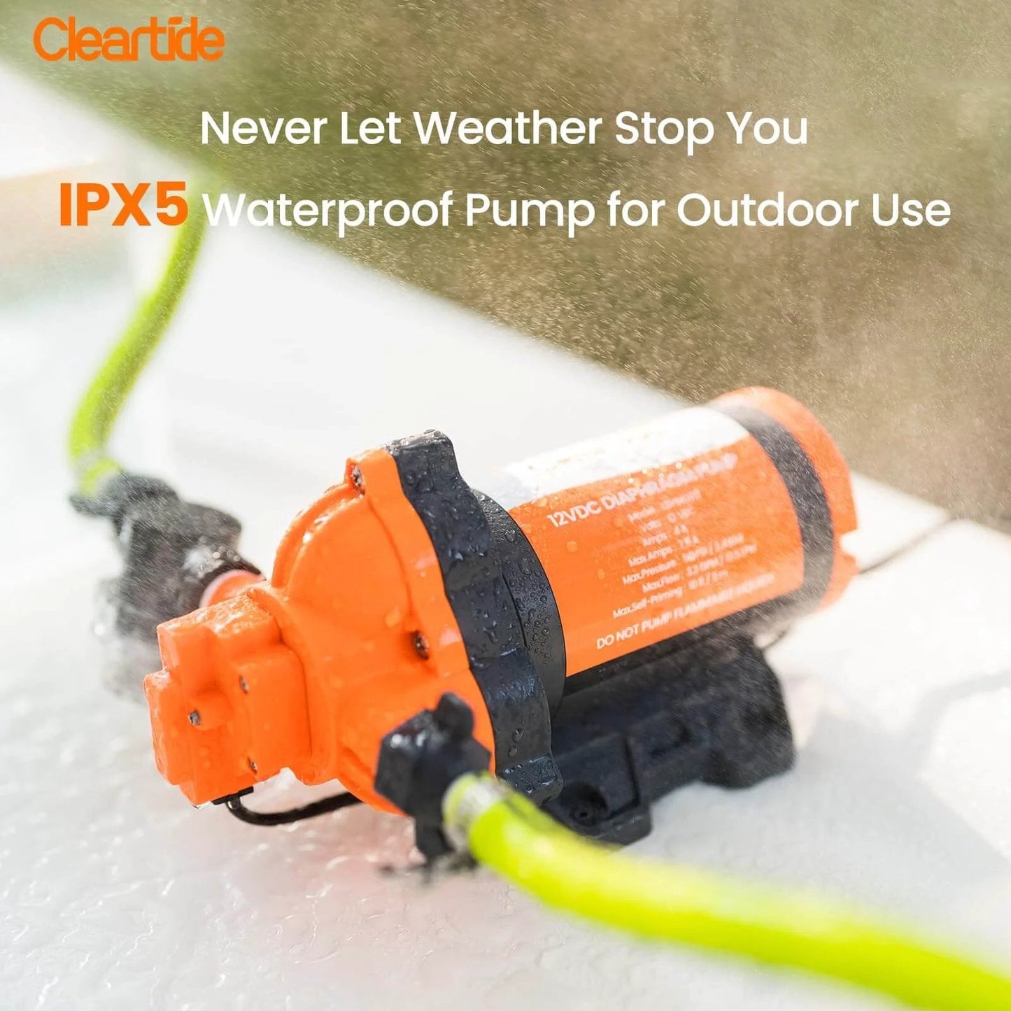 IPX5 rated Cleartide Diaphragm Water Pump, 115V, 3.3 GPM, 50 PSI, shown in wet outdoor use with orange casing and green hose.