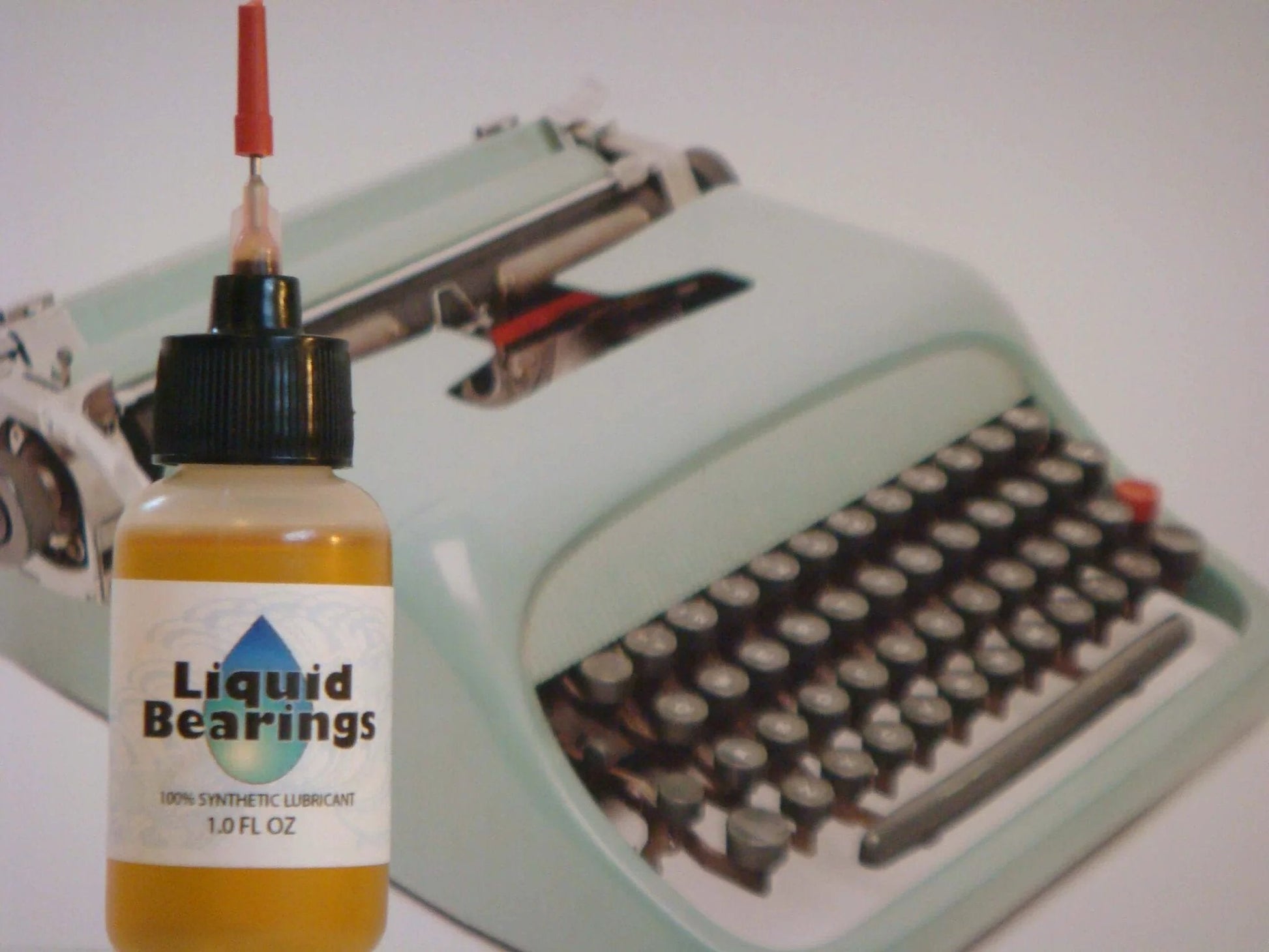 Liquid Bearings, SUPERIOR 100%-synthetic oil for lubrication of drones, RC vehicles and equipment, 1 oz bottle next to typewriter