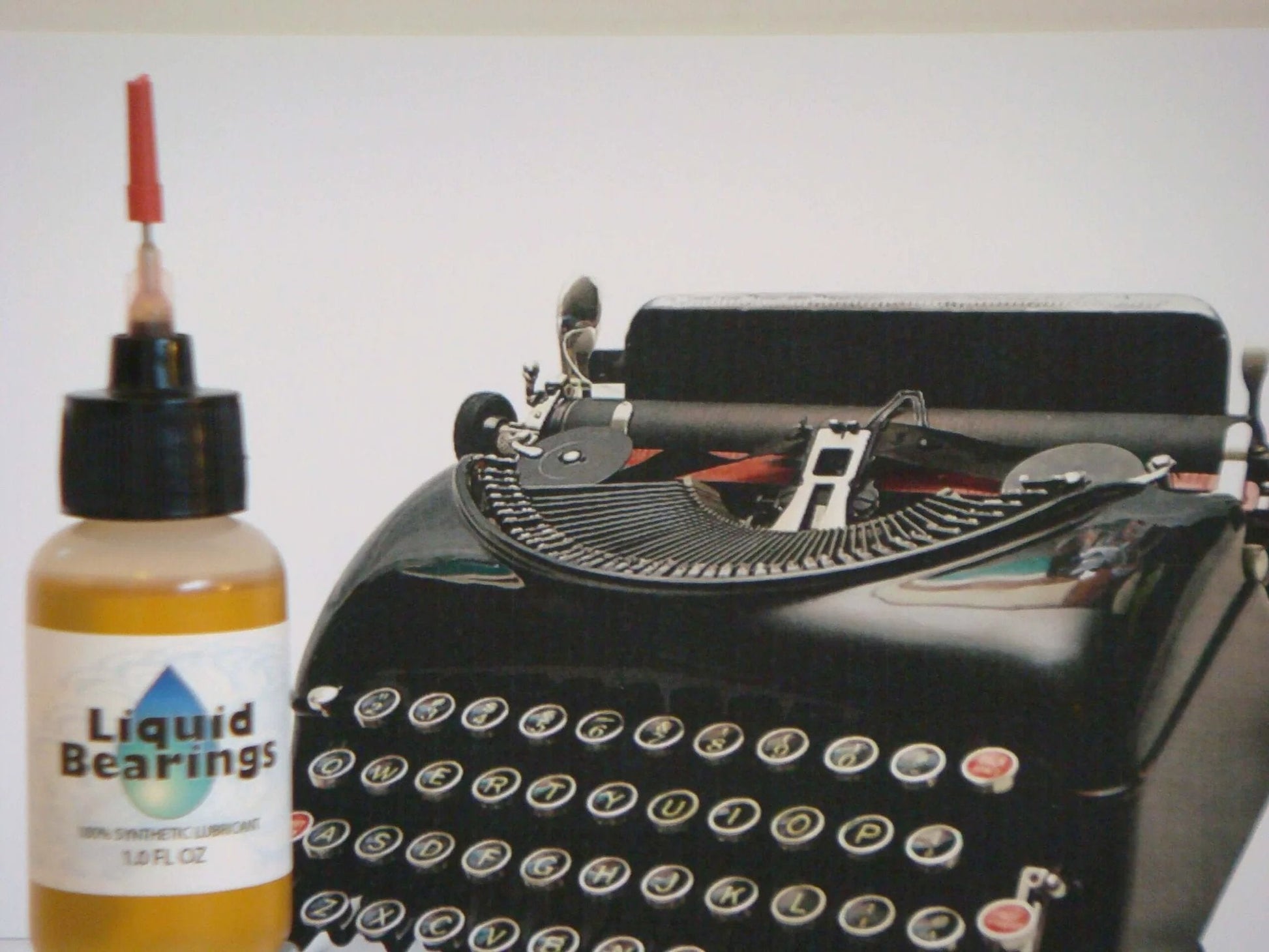 Liquid Bearings, SUPERIOR 100%-synthetic oil for lubrication of drones, RC vehicles and equipment next to a vintage typewriter.