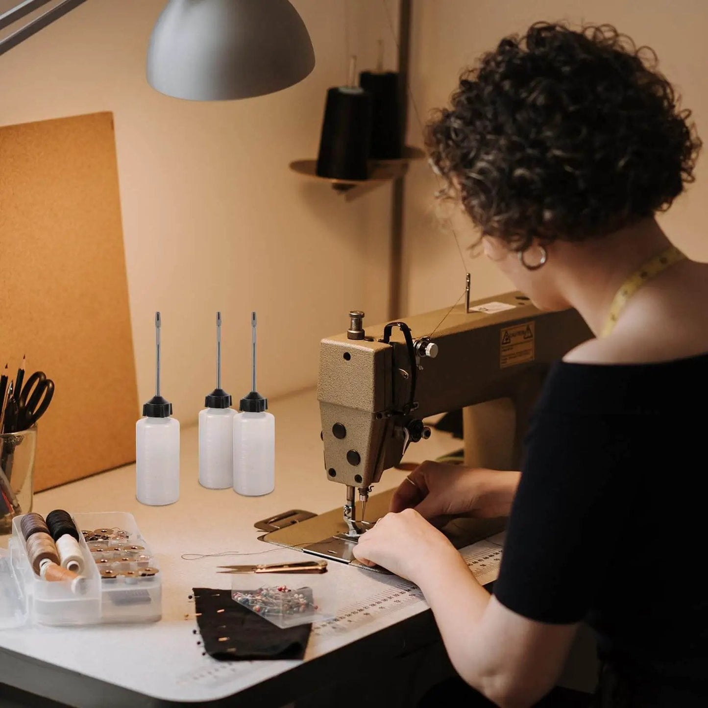 Woman using sewing machine with long mouth nozzle oil bottles for sewing machines and home tools three pack plastic oiler pots nearby