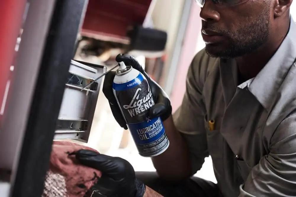 Person applying Heavy Duty Lubricating Oil For Tools And Machinery 11 Oz Keeps Moving Parts Slick Quiet And Rust Free from Liquid Wrench.
