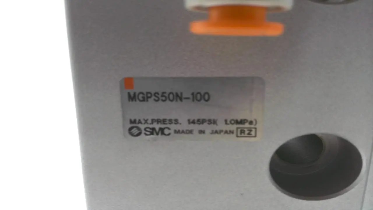 Close-up of MGP Compact Guide Cylinder 50mm Heavy Duty Actuator MGPS50N-100 label, showing SMC branding and pressure rating.