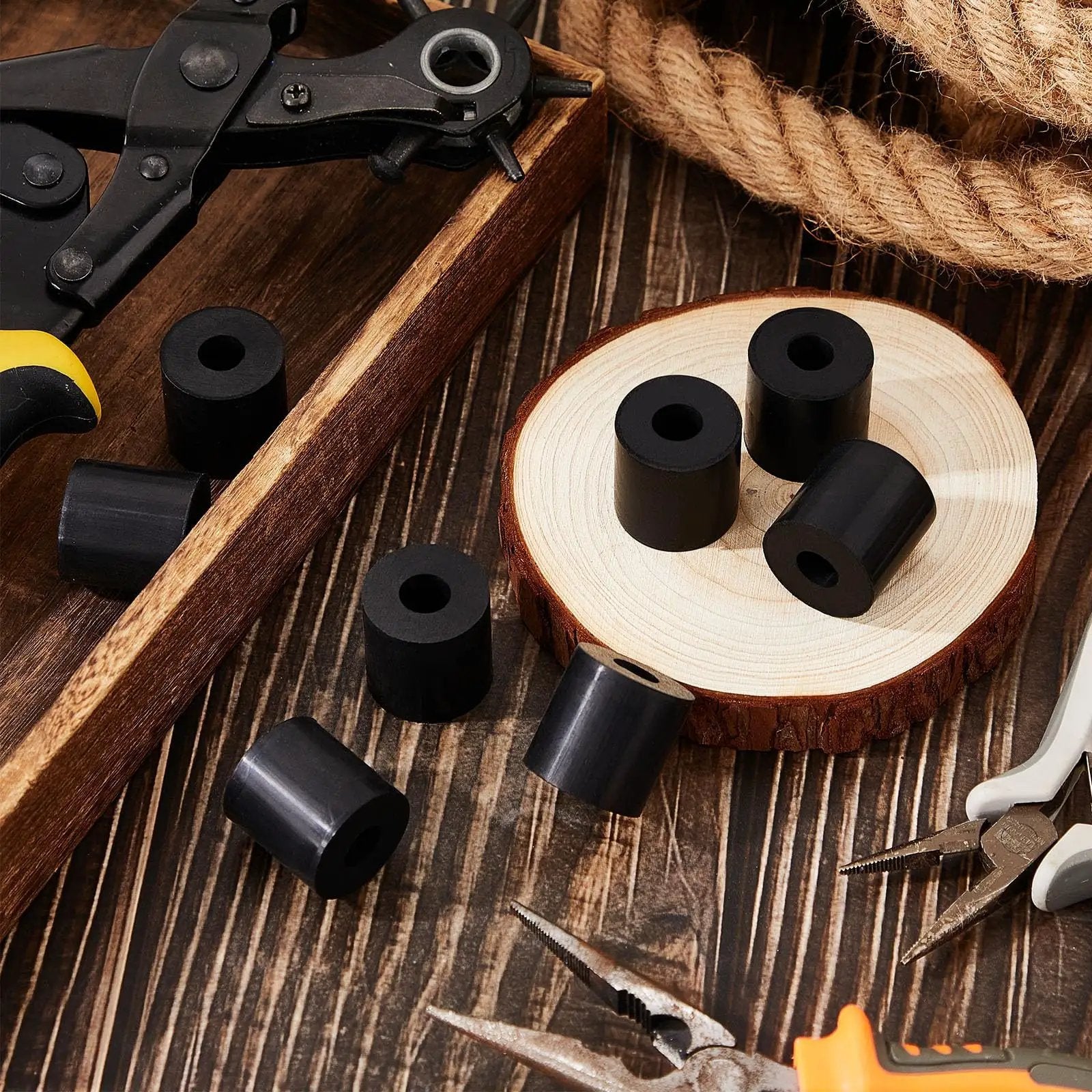 Eight Pack Rubber Spacers 1 Inch OD By Three Eighths Inch ID By 1 Inch Thick Neoprene Washers among tools on wood surface