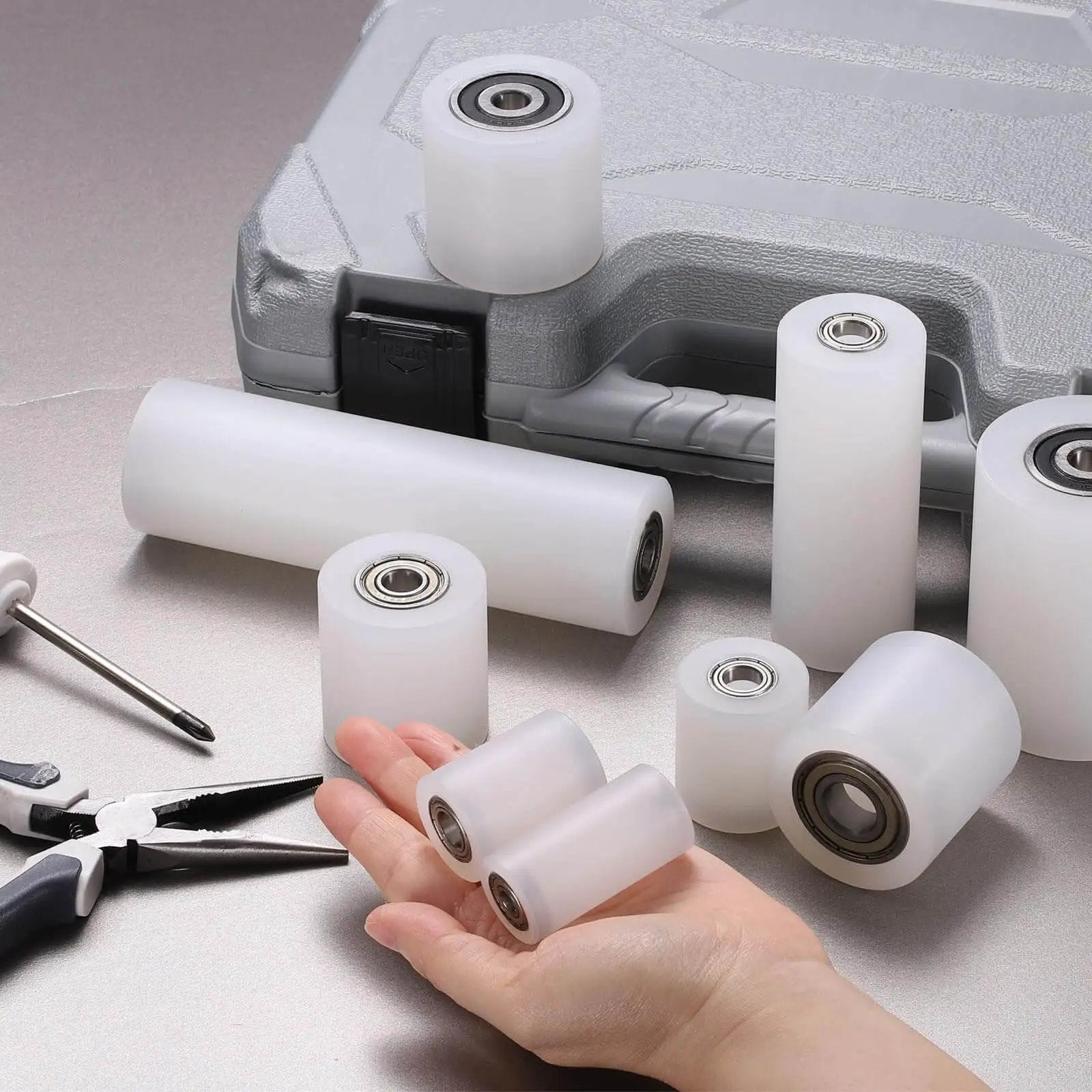 Nylon Roller Wheel Set With 686Z Bearings One Quarter Inch Bore One Inch Outer Diameter One Inch Length Four Pieces CNC Guiding Wheel Flat Belt Idler Pulley White for Conveyor And 3D Printer Projects, displayed with tools.