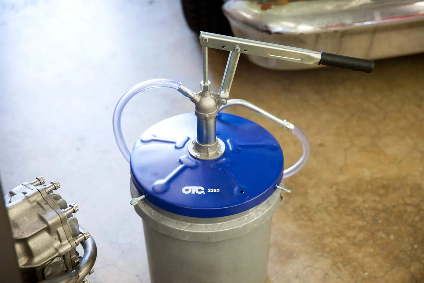 OTC 2352 Lever Action Bucket Pump on 5-gallon pail with hose and handle mechanism for oil distribution