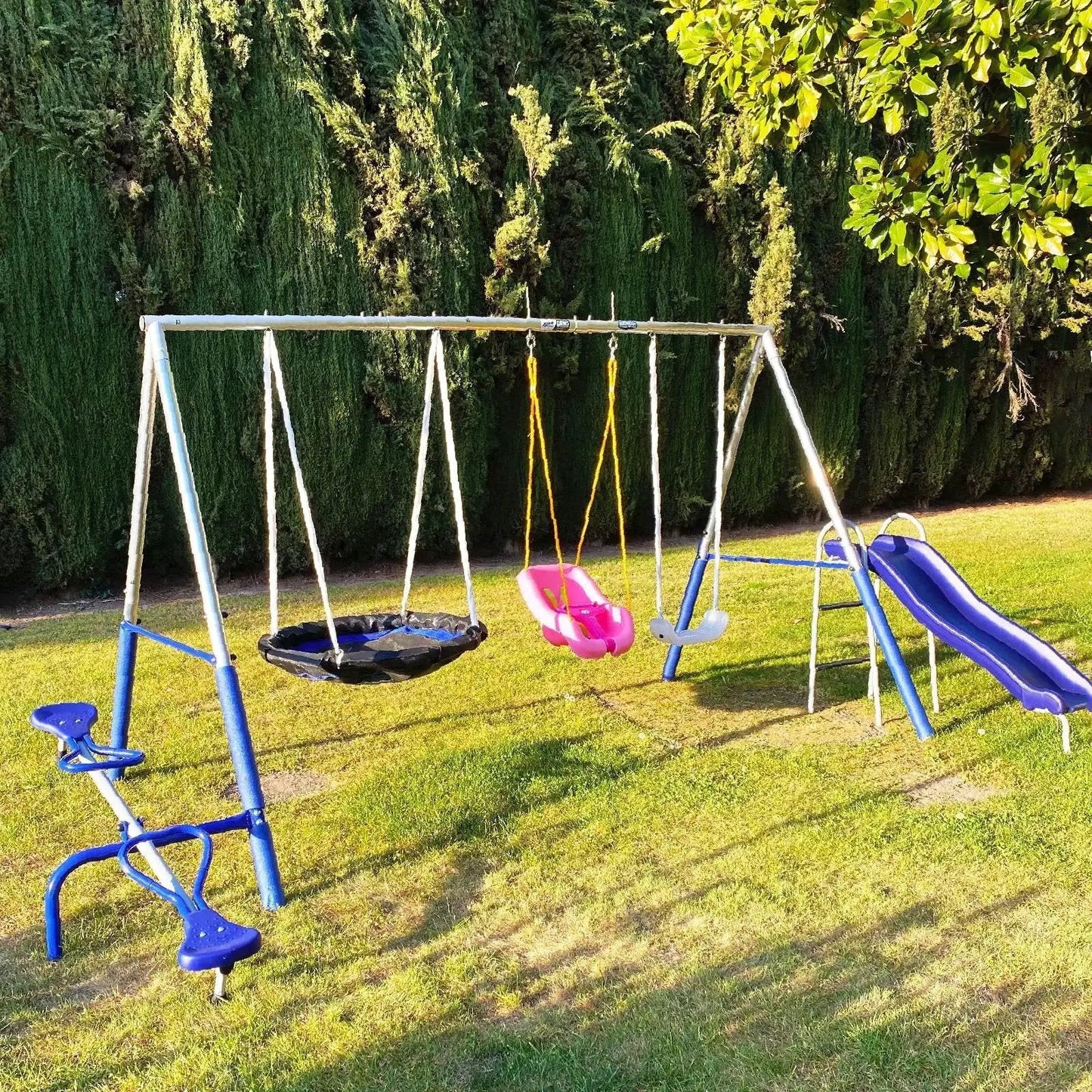 Outdoor playground swing set with slide and seats on grassy lawn
