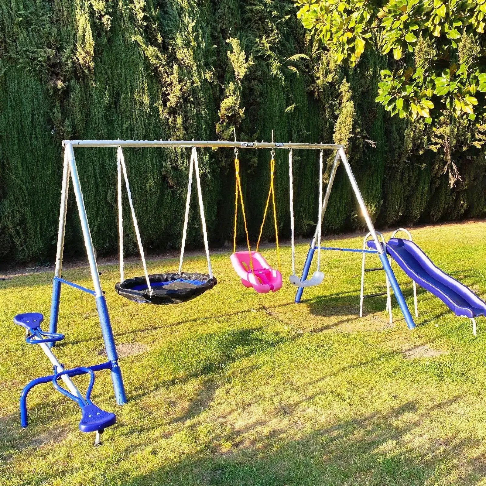 Outdoor playground swing set with slide and seats on grassy lawn